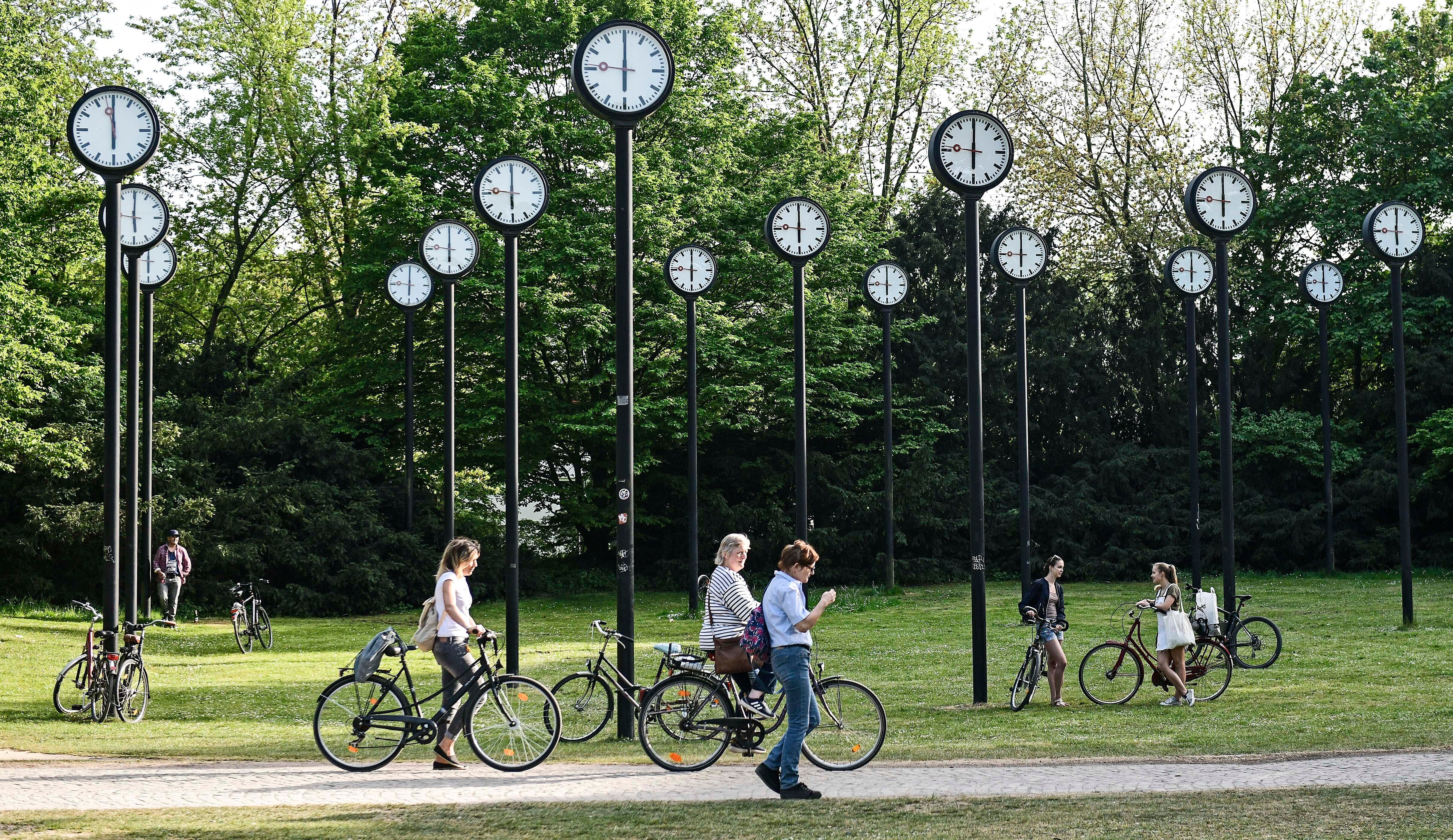 People with bicycles meet at the clock park in Duesseldorf, Germany