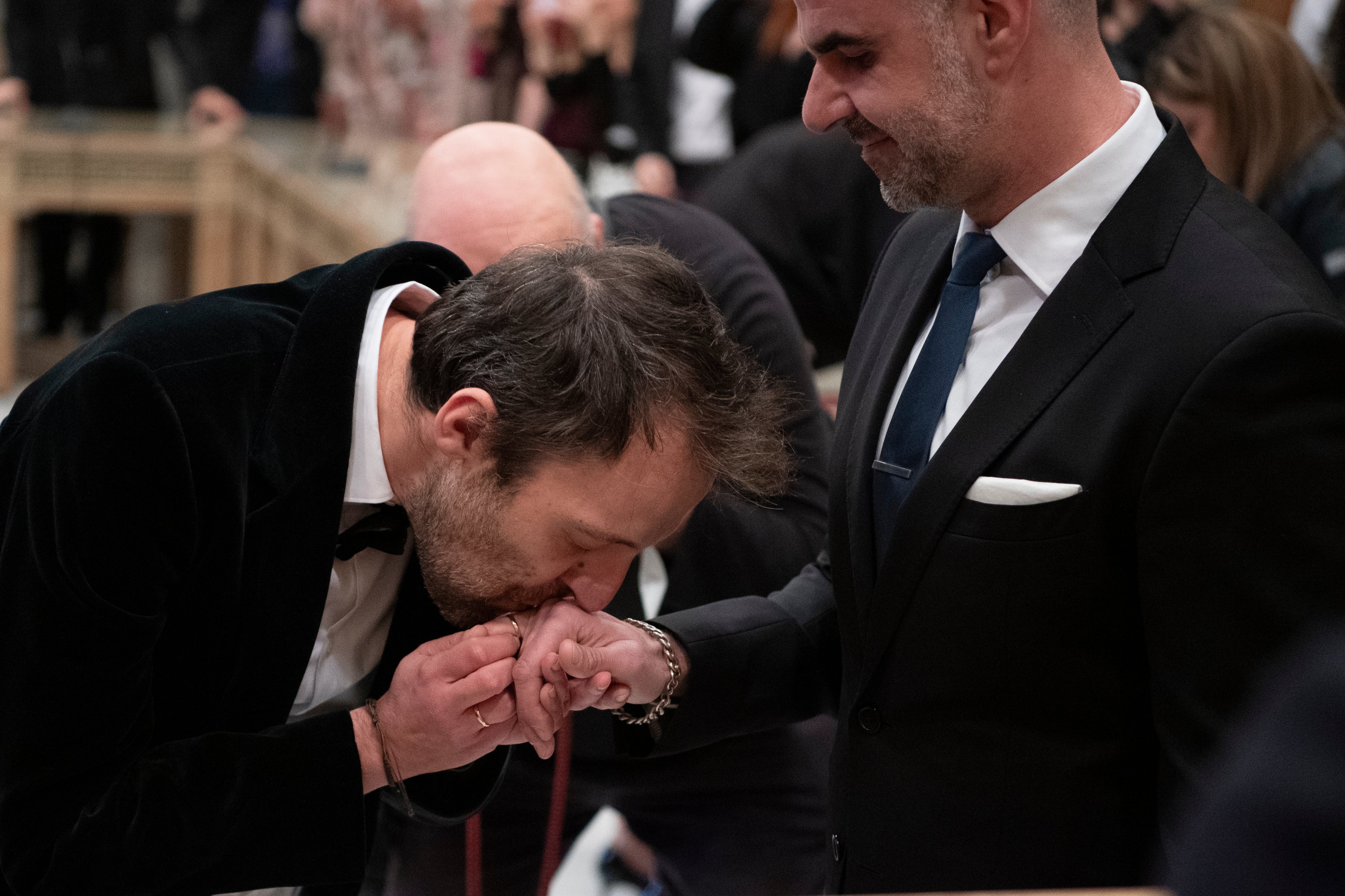 Greek author Petros Hadjopoulos, who uses the pen name Auguste Corteau, kisses his husband's hand, lawyer Anastasios Samouilidis, during their wedding at Athens City Hall, Greece, on Thursday, March 7, 2024