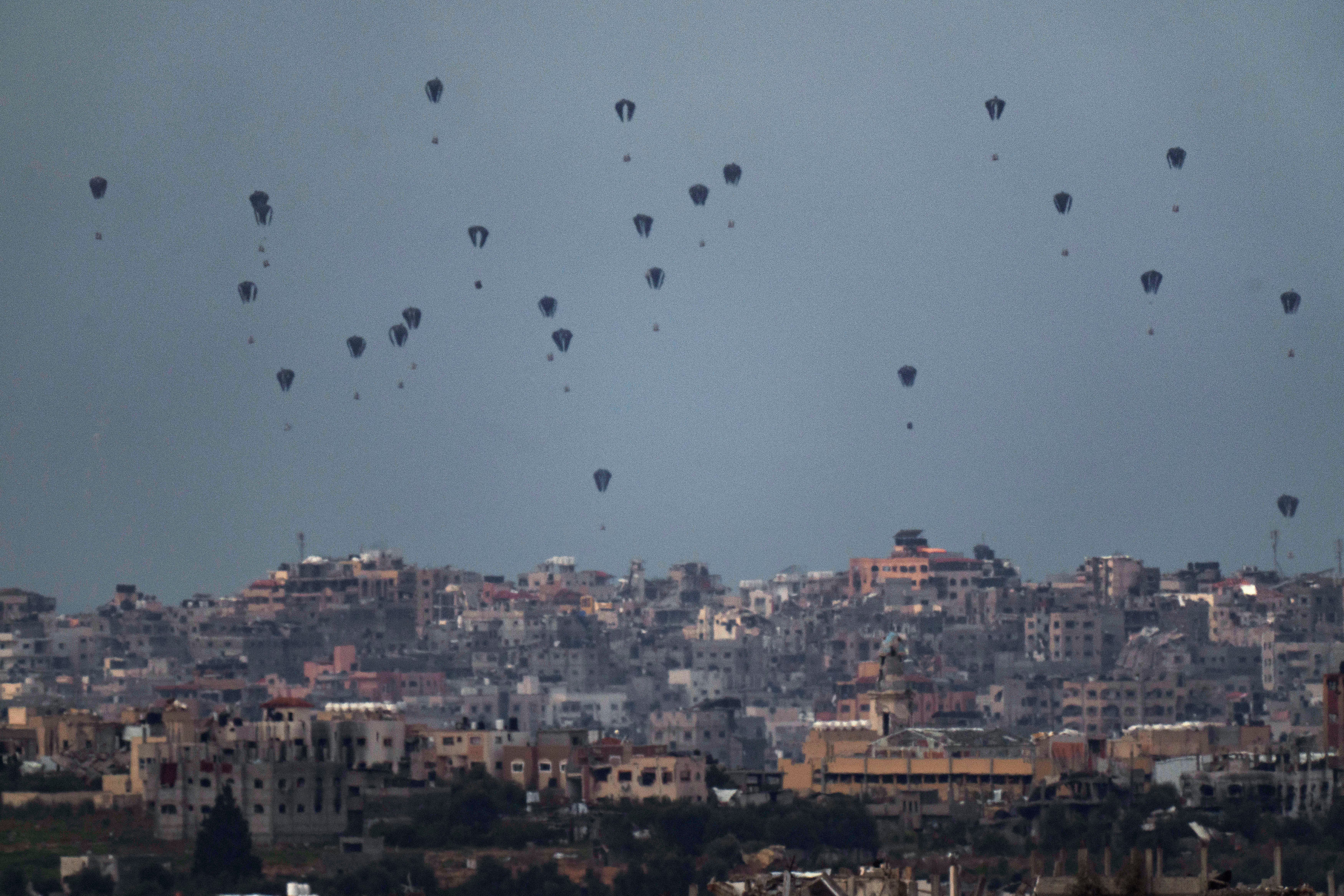 Parachutes drop supplies into the northern Gaza Strip. US and UK aid could now reach Gaza by sea after President Biden announced plans to create a temporary port in the territory (AP Photo/Leo Correa)