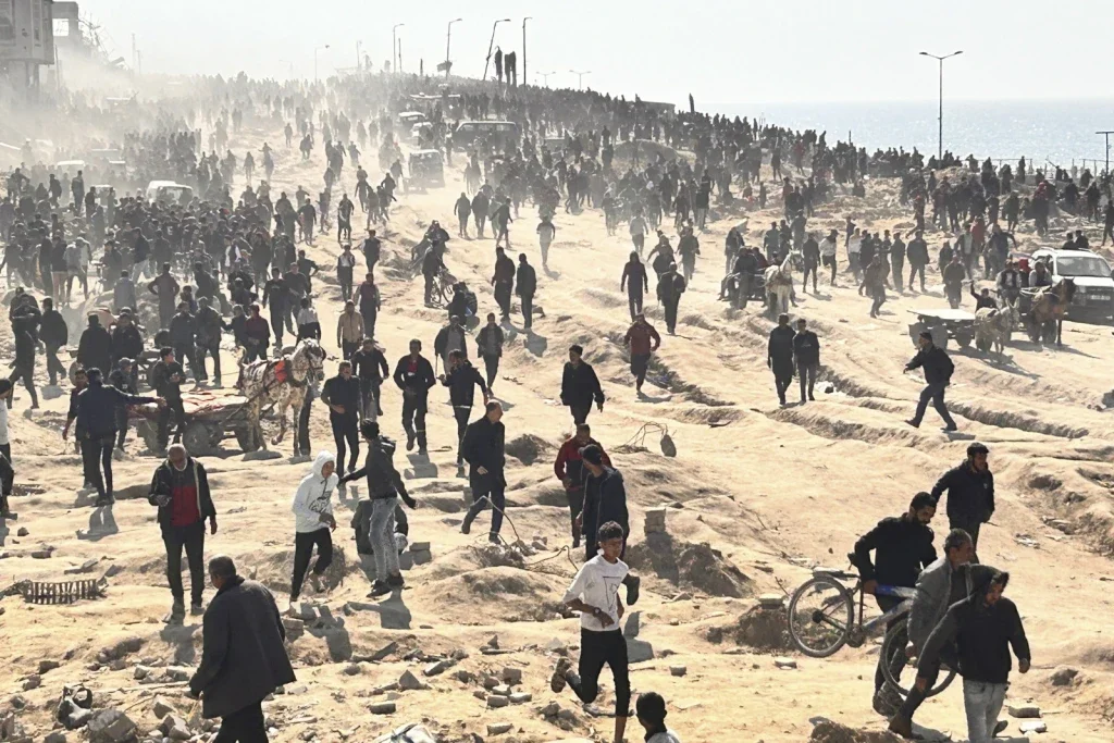 Palestinians wait for humanitarian aid on a beachfront in Gaza