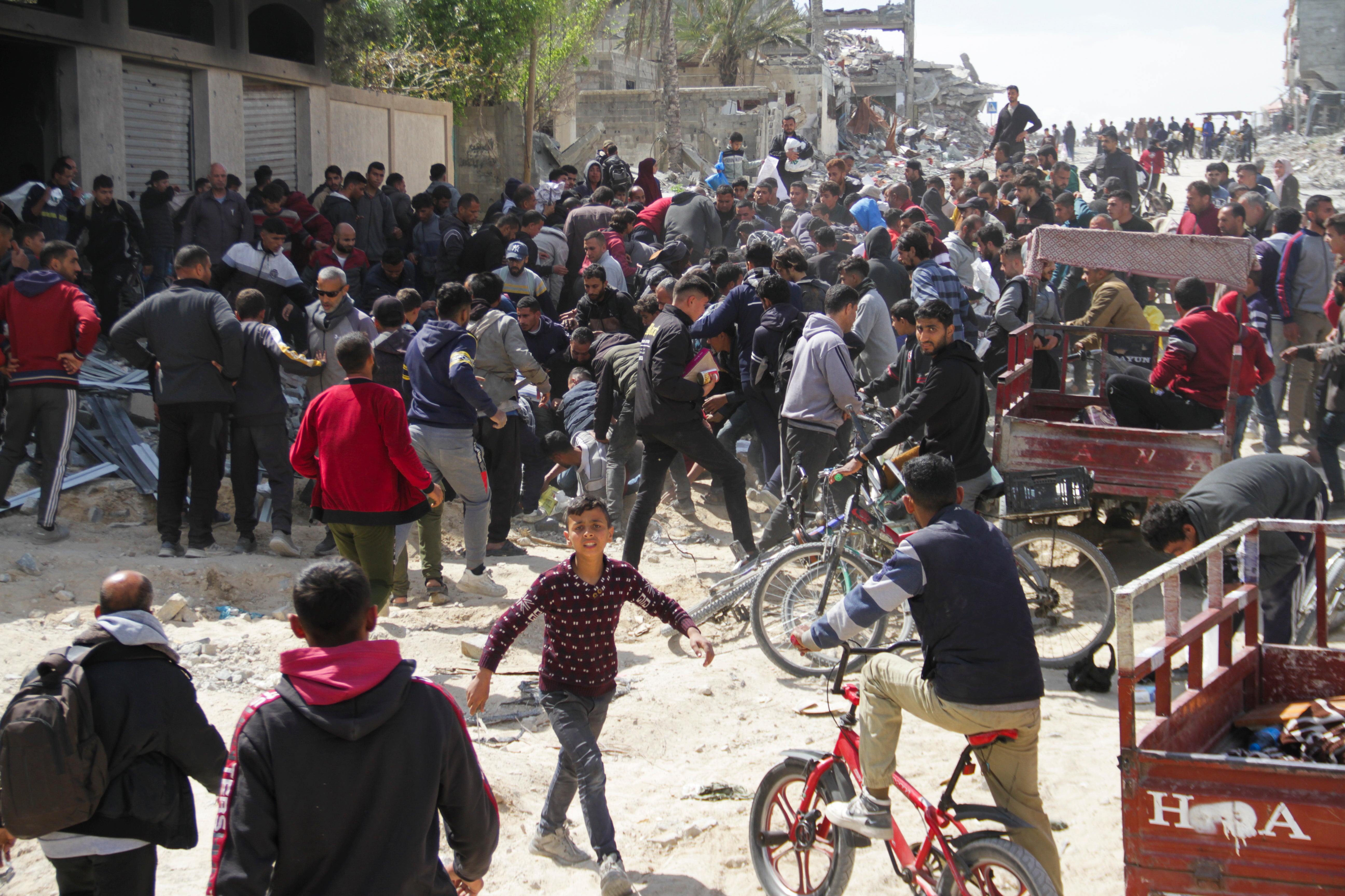 Palestinians rush to get humanitarian aid dropped by the US Air Force into Gaza City