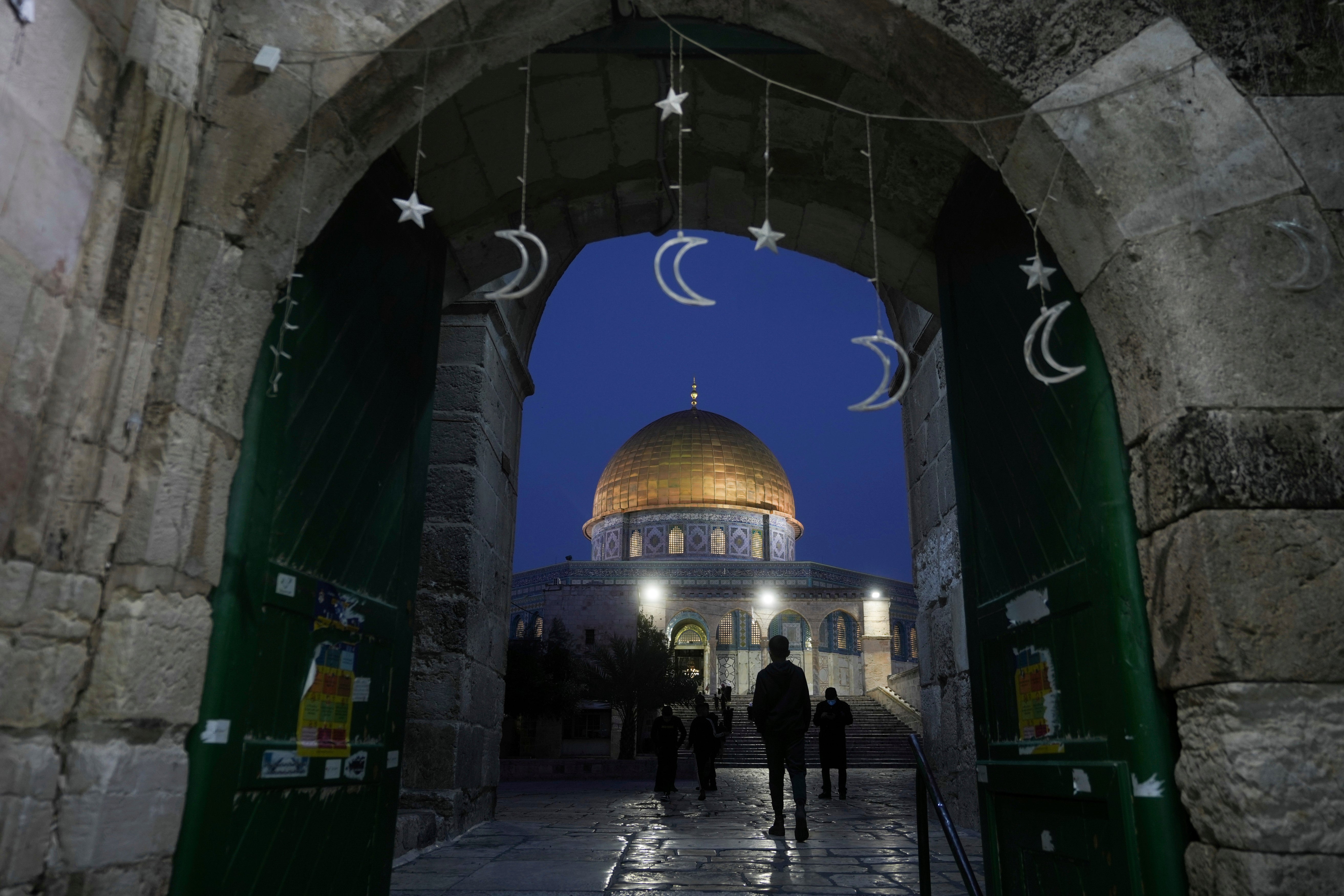 Muslims walk next to the Dome of Rock Mosque at the Al-Aqsa Mosque compound in Jerusalem’s Old City