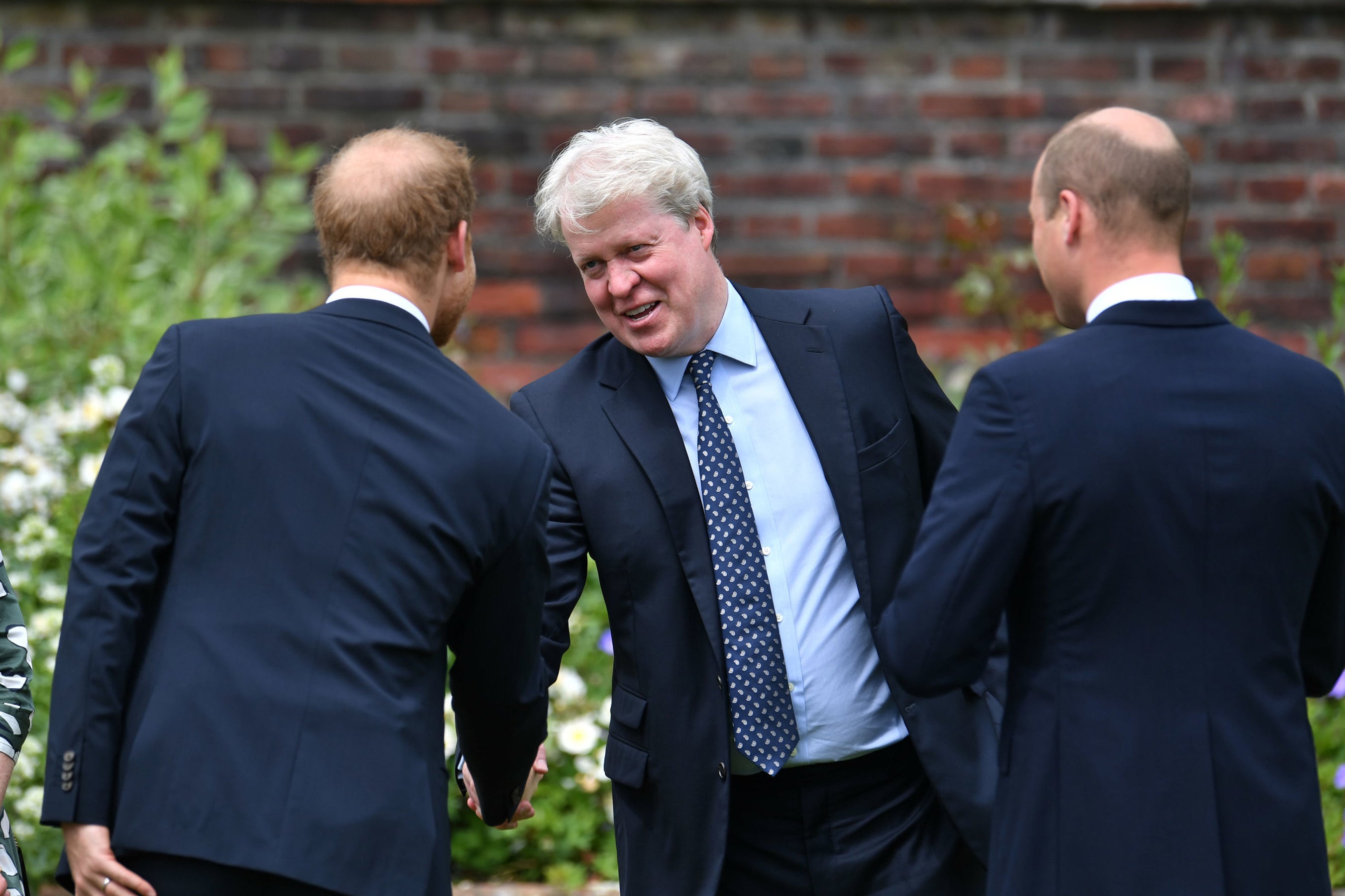Earl Spencer is greeted by his nephews Prince William and Prince Harry at an unveiling of a statue of Princess of Wales at Kensington Palace on 1 July 2021