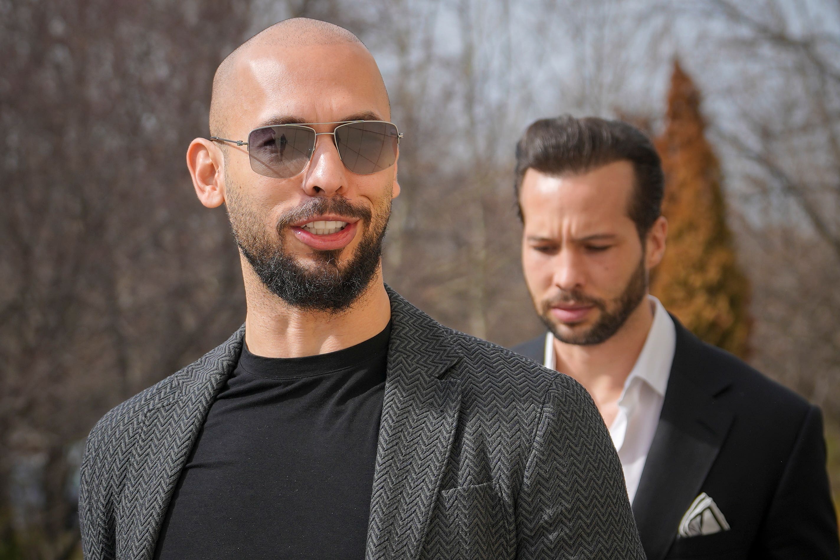 Andrew Tate, left, and his brother Tristan arrive at the Bucharest Tribunal in Romania (Vadim Ghirda/AP)