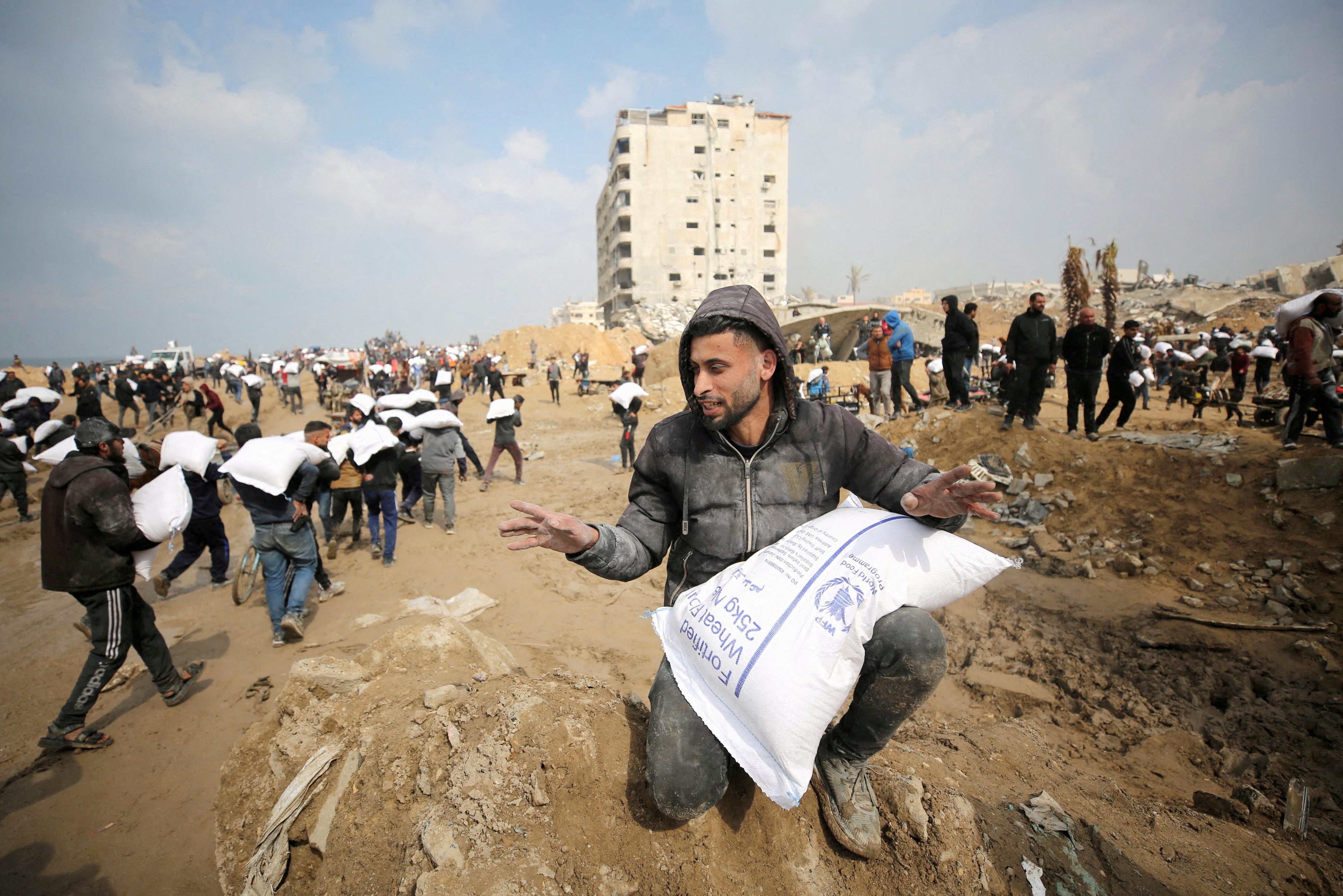 Palestinians carry bags of flour from an aid truck in Gaza City last month