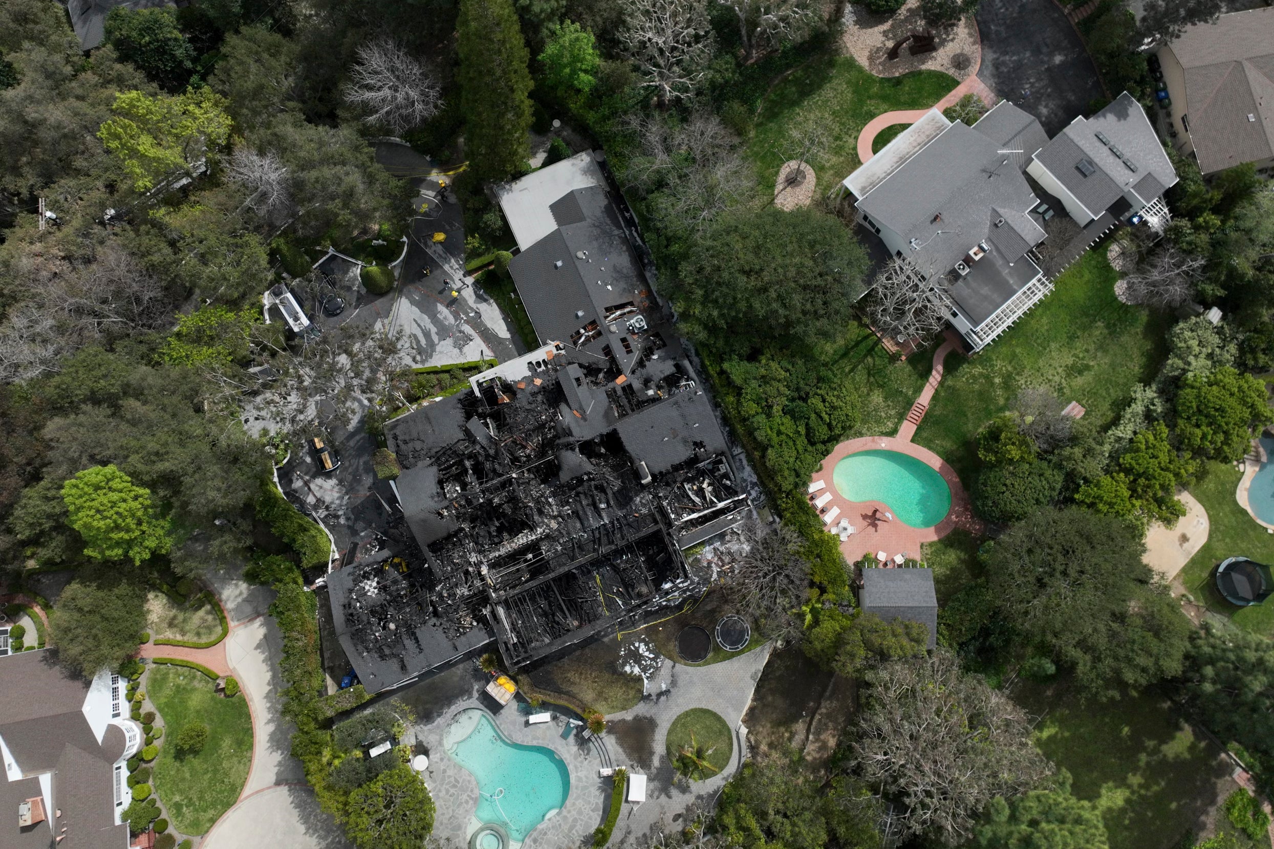 An aerial view shows a fire-damaged property, which appears to belong to Cara Delevingne