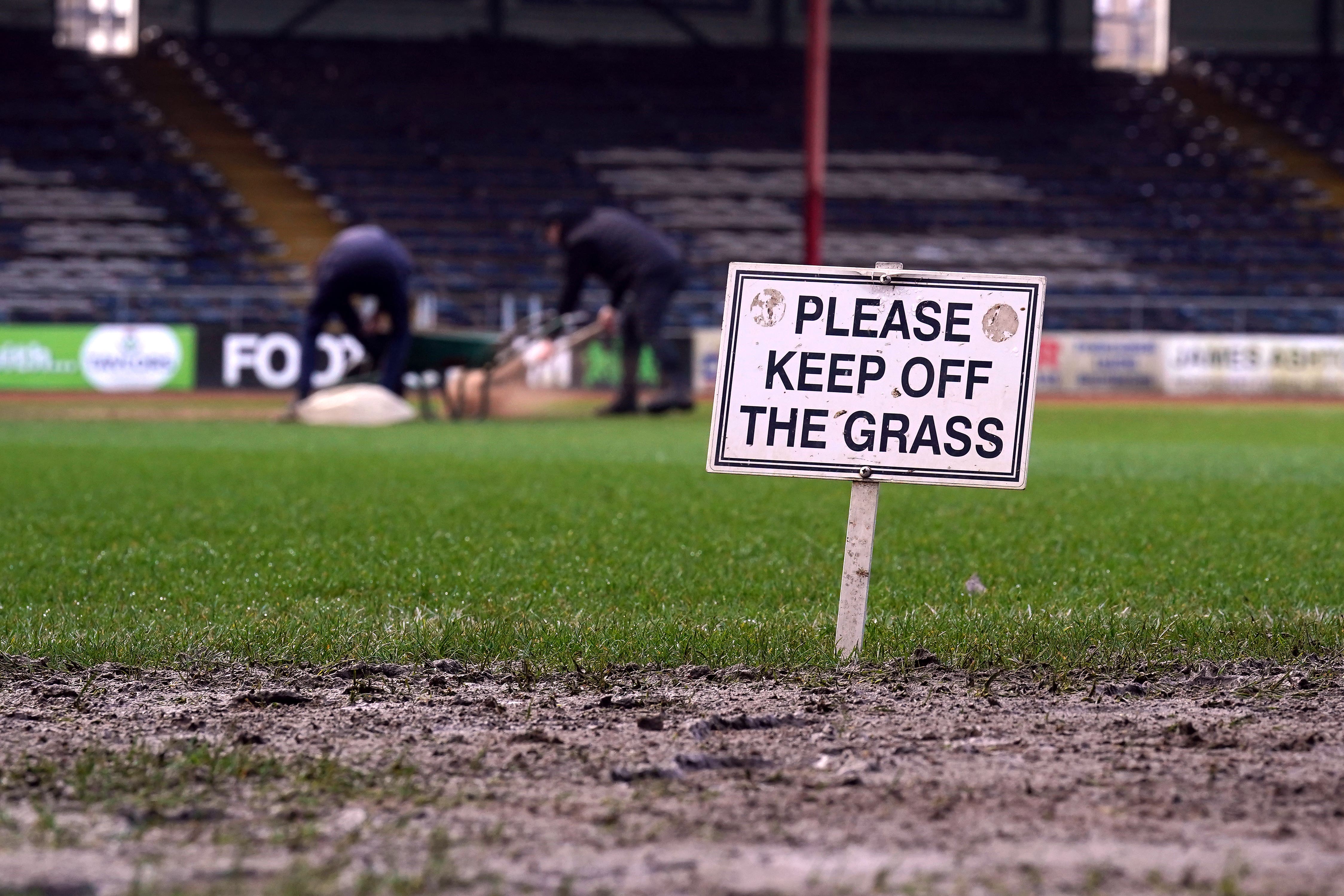 Ground staff work on the pitch at Dens Park (Andrew Milligan/PA)