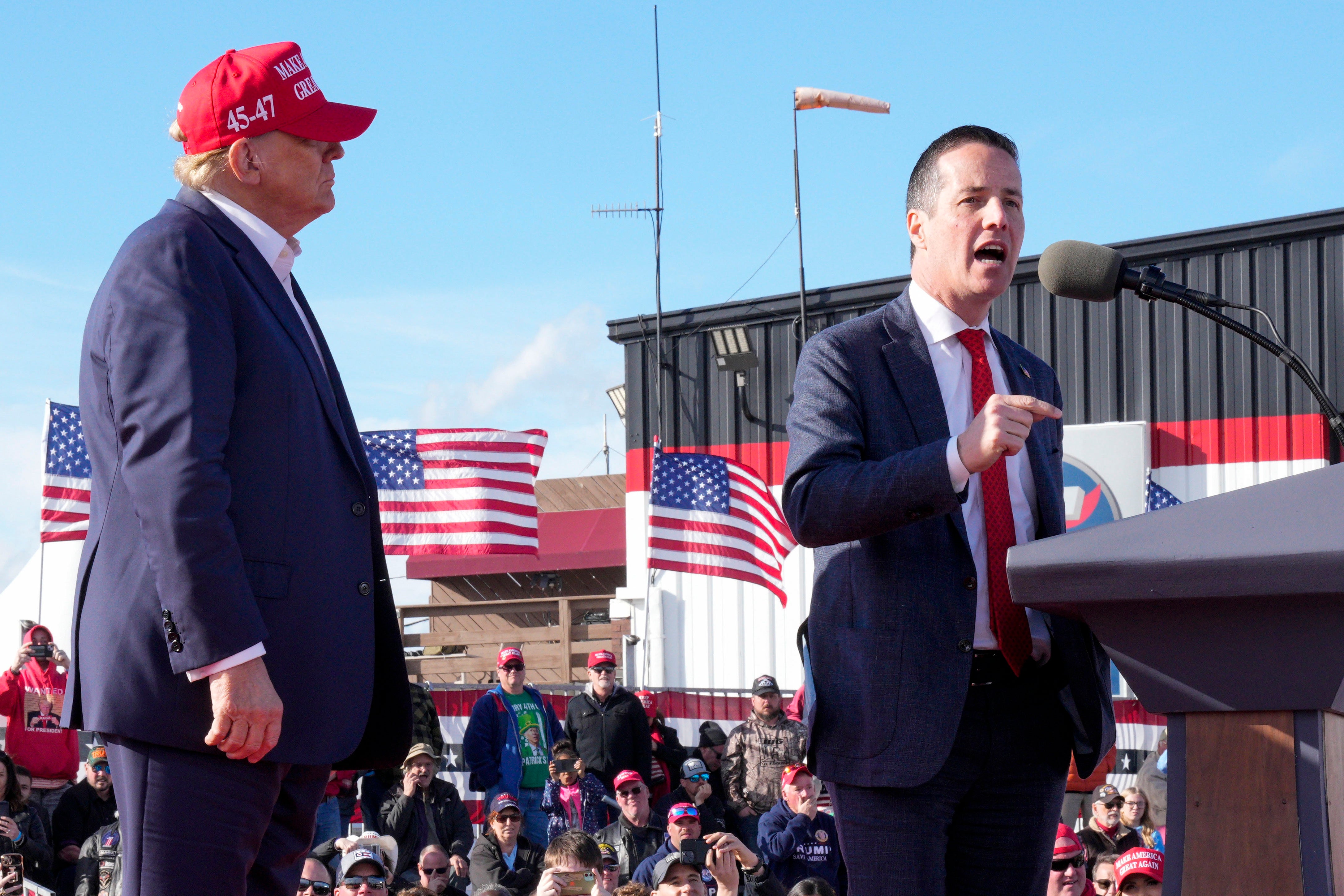 Donald Trump looks on as his favoured candidate for the US Senate, Bernie Moreno, speaks at a rally in Dayton