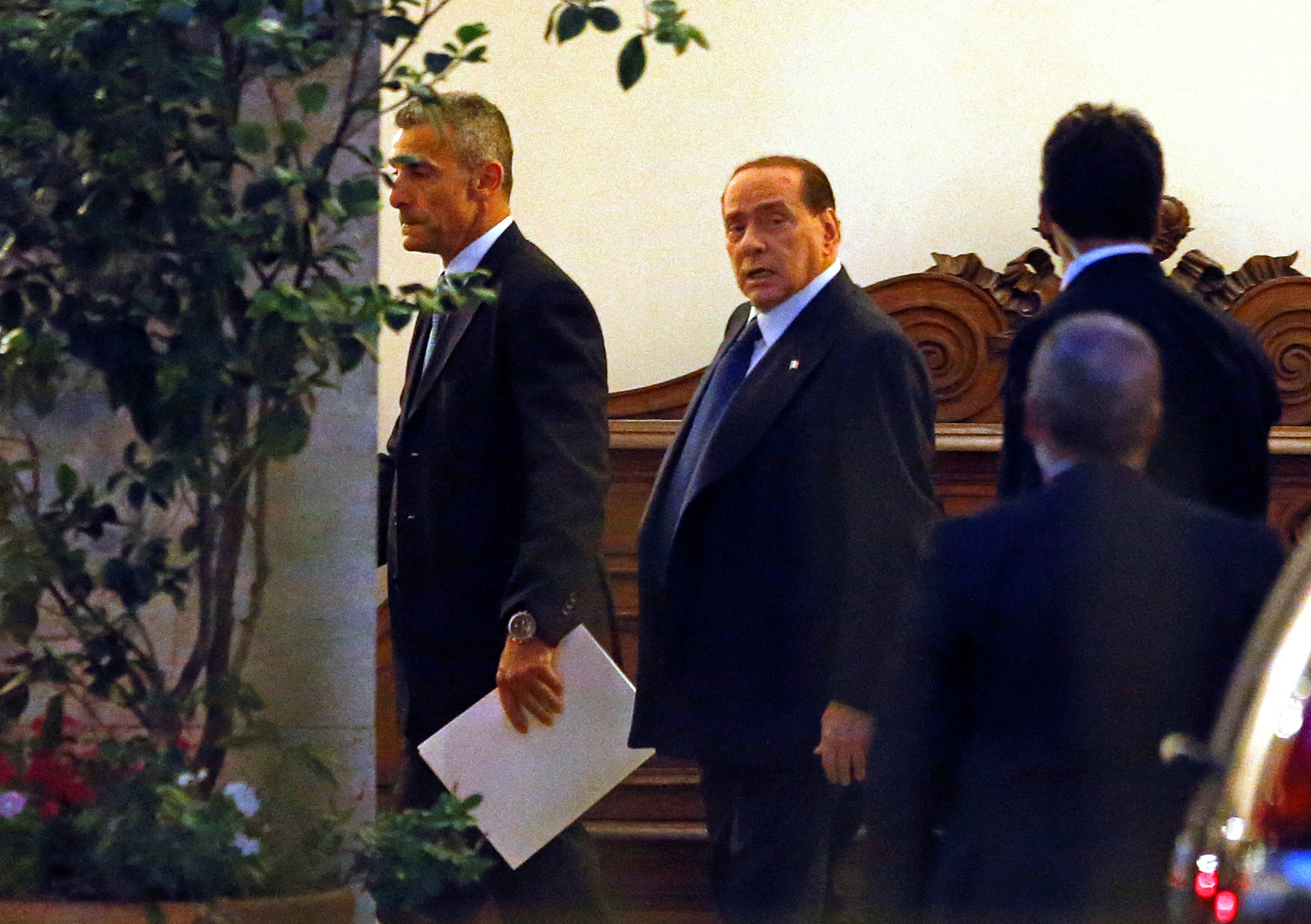 Italy's former Prime Minister Silvio Berlusconi (C) leaves his residence at Grazioli palace, downtown Rome June 25, 2013. REUTERS/Tony Gentile/File Photo