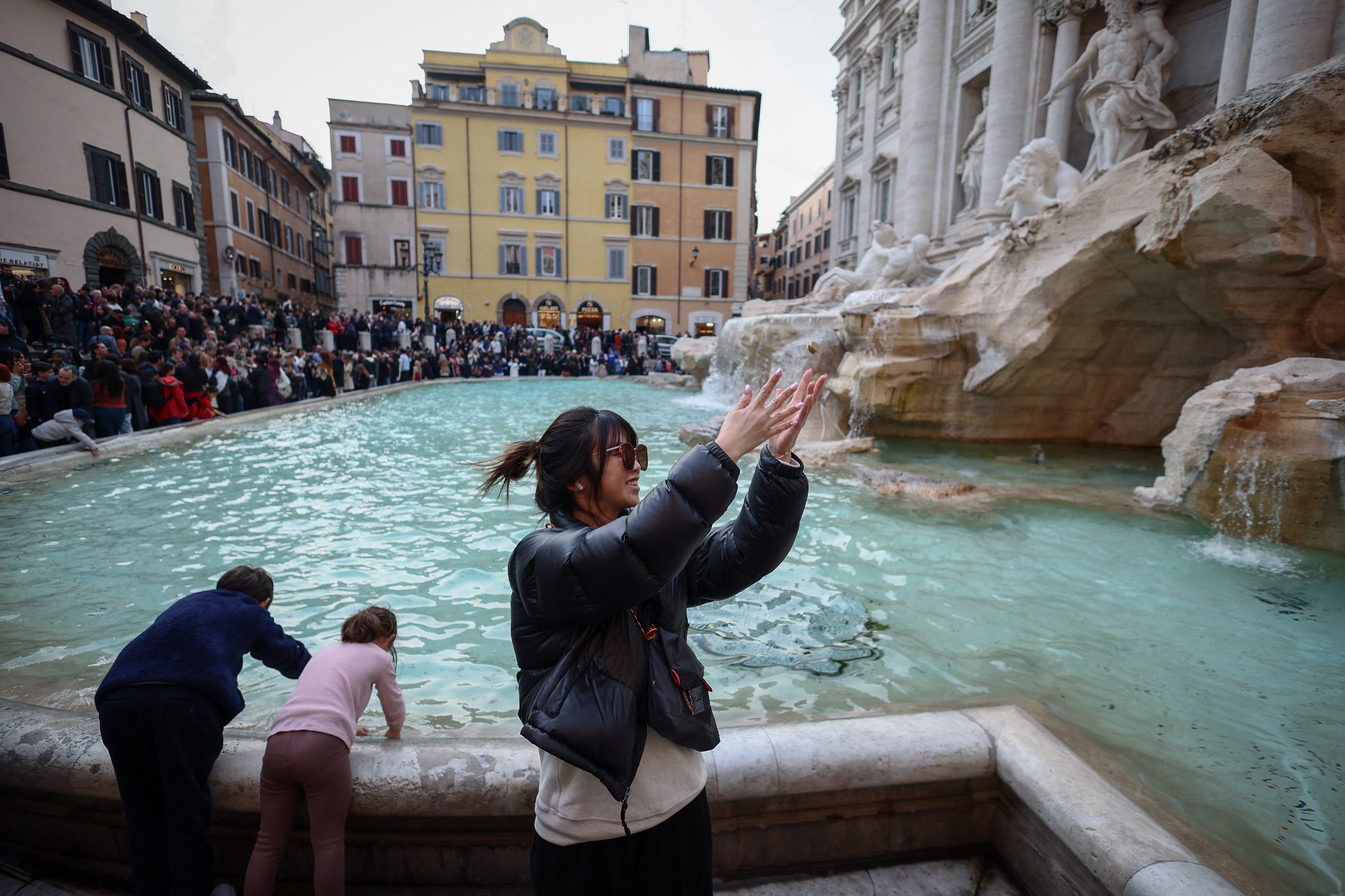 Yuting, from China, throws two coins into the fountain