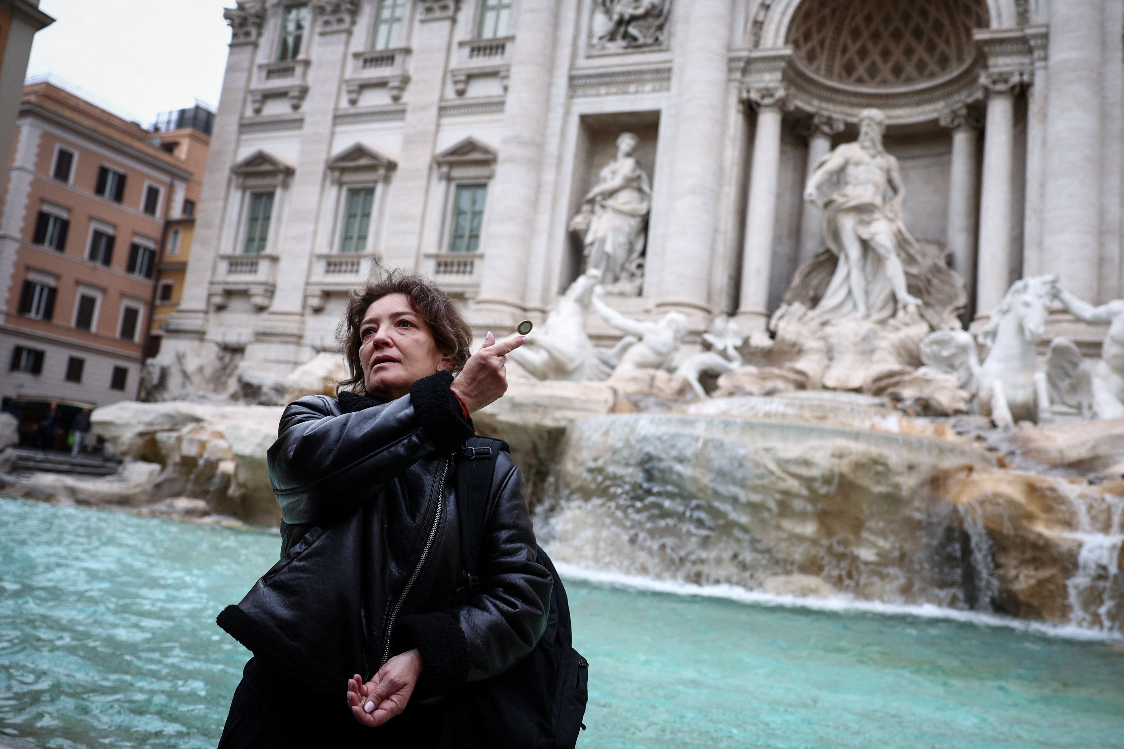 Carola, from Chile, throws a coin into the Trevi Fountain in Rome, Italy, February 19, 2024