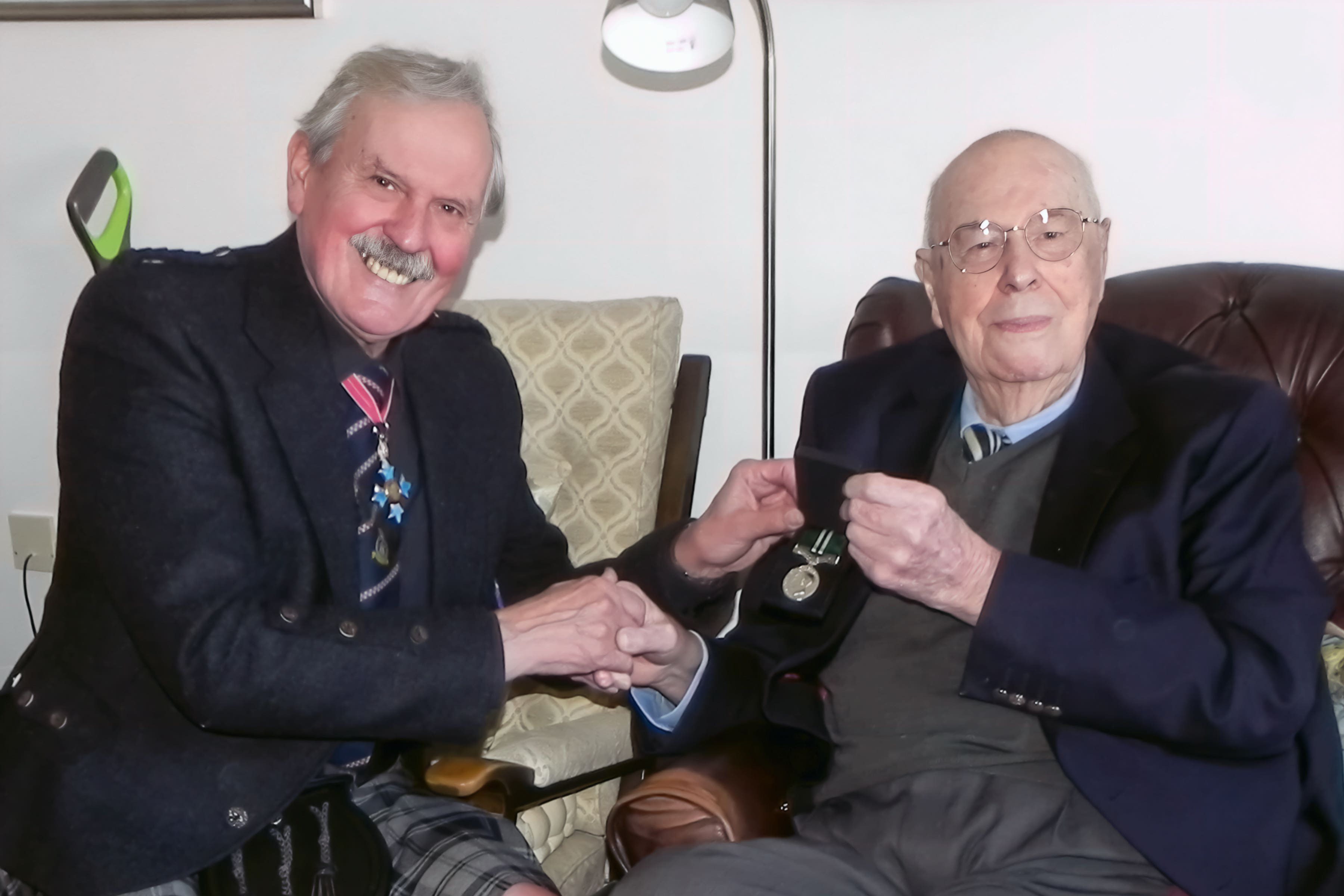 John Cruickshank receives his overdue Air Efficiency Award from retired group captain Bob Kemp of the Royal Auxiliary Air Force Foundation (Bob Kemp/PA)