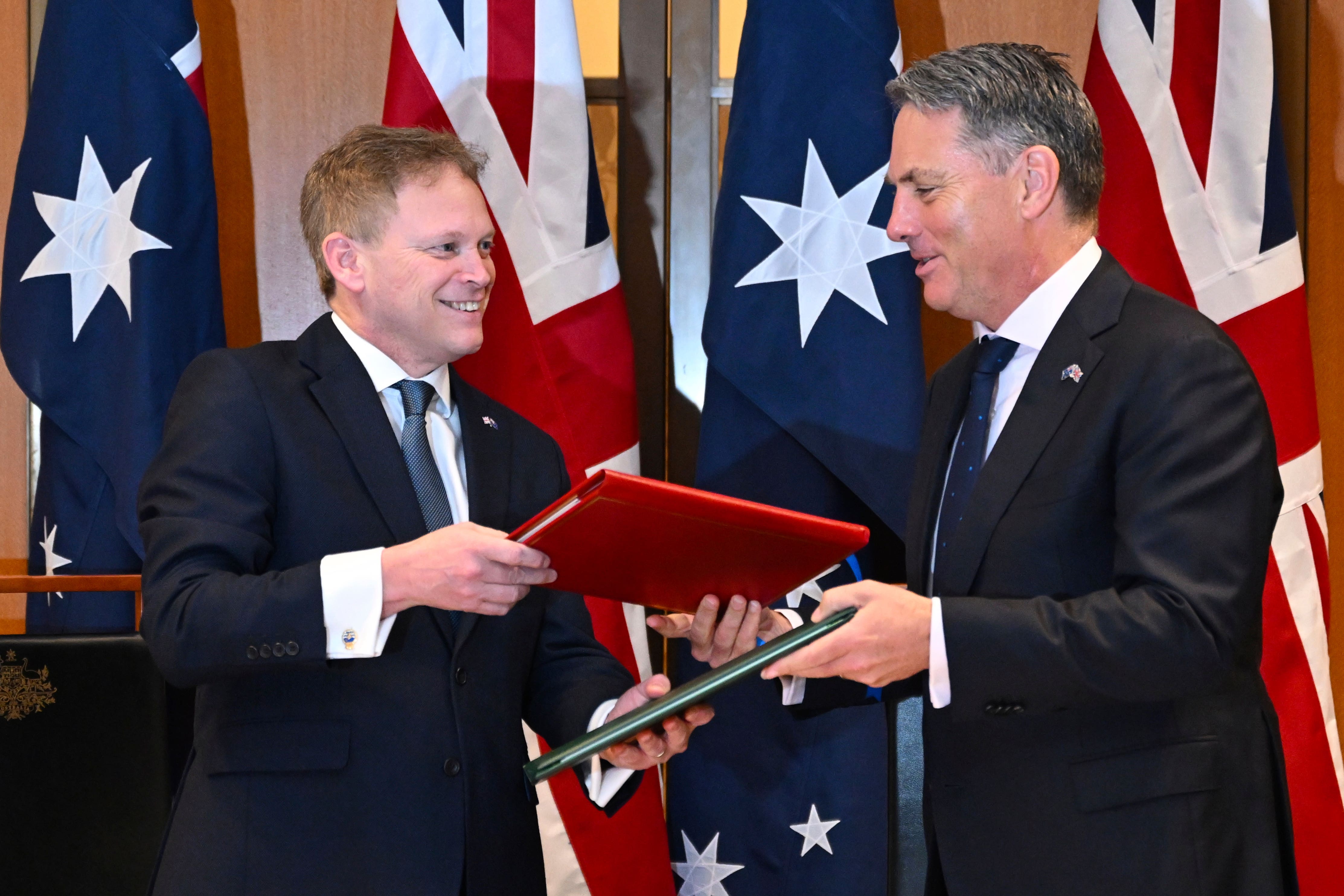 Defence Secretart Grant Shapps, left, and his Australian counterpart Richard Marles exchange the treaty (Lukas Coch/AAP Image/AP)