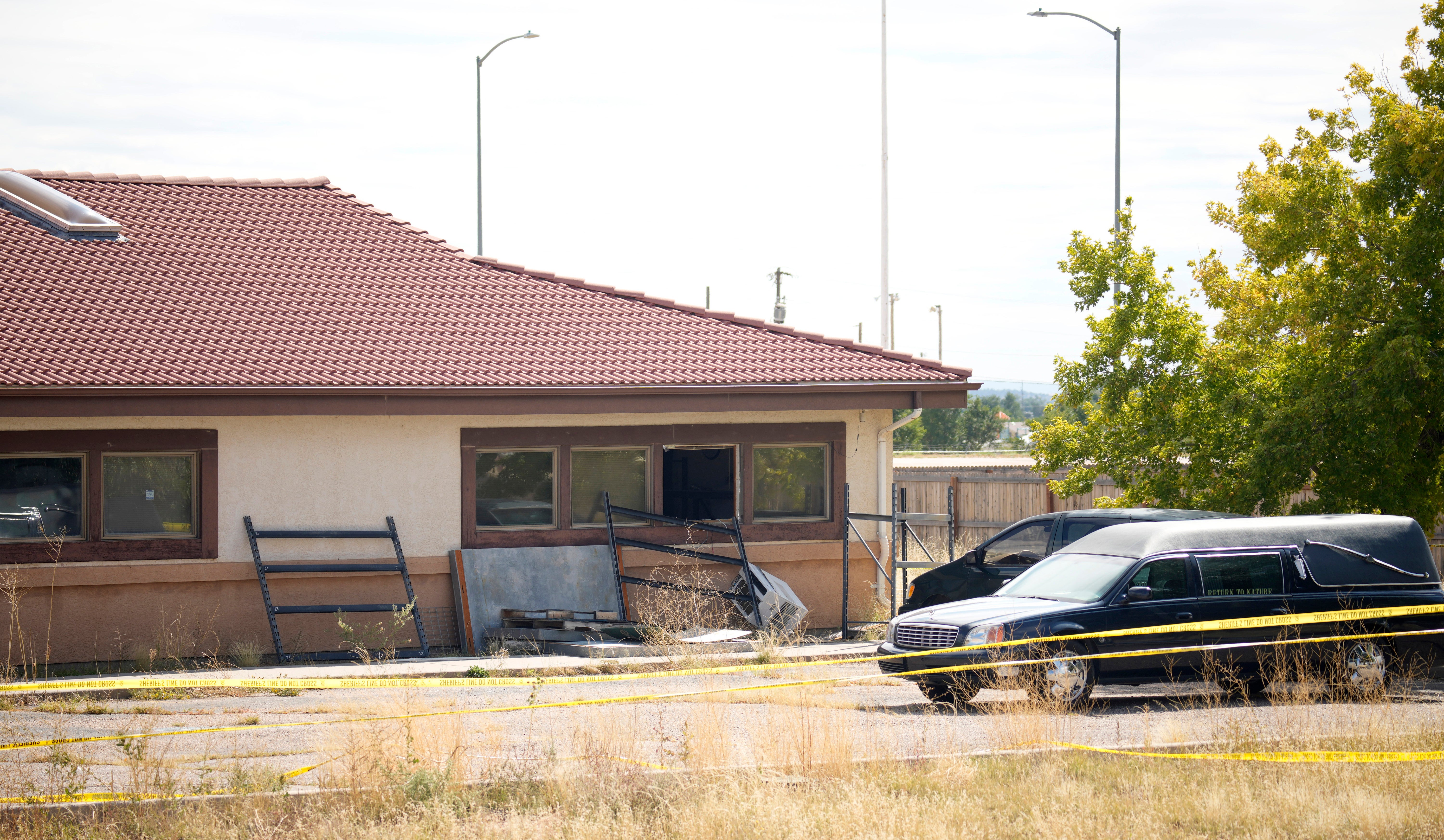 A hearse and van sit outside the Return to Nature Funeral Home on October 6, 2023, in Penrose, Colorado; the owners were arrested after authorities discovered nearly 200 decaying bodies at the property