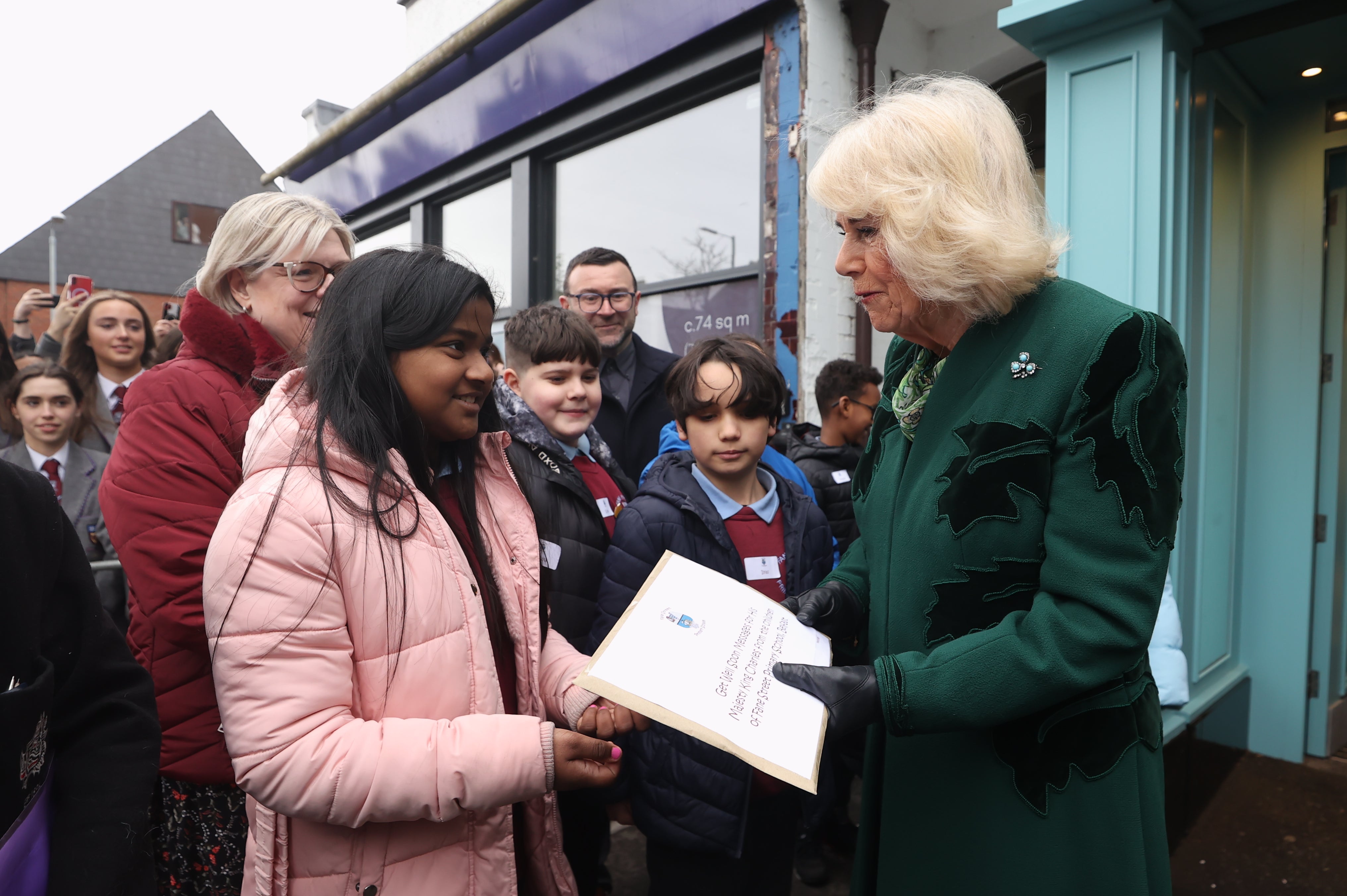 Queen Camilla recieves a message of goodwill during a visit to Lisburn Road in Belfast to meet shop owners and staff