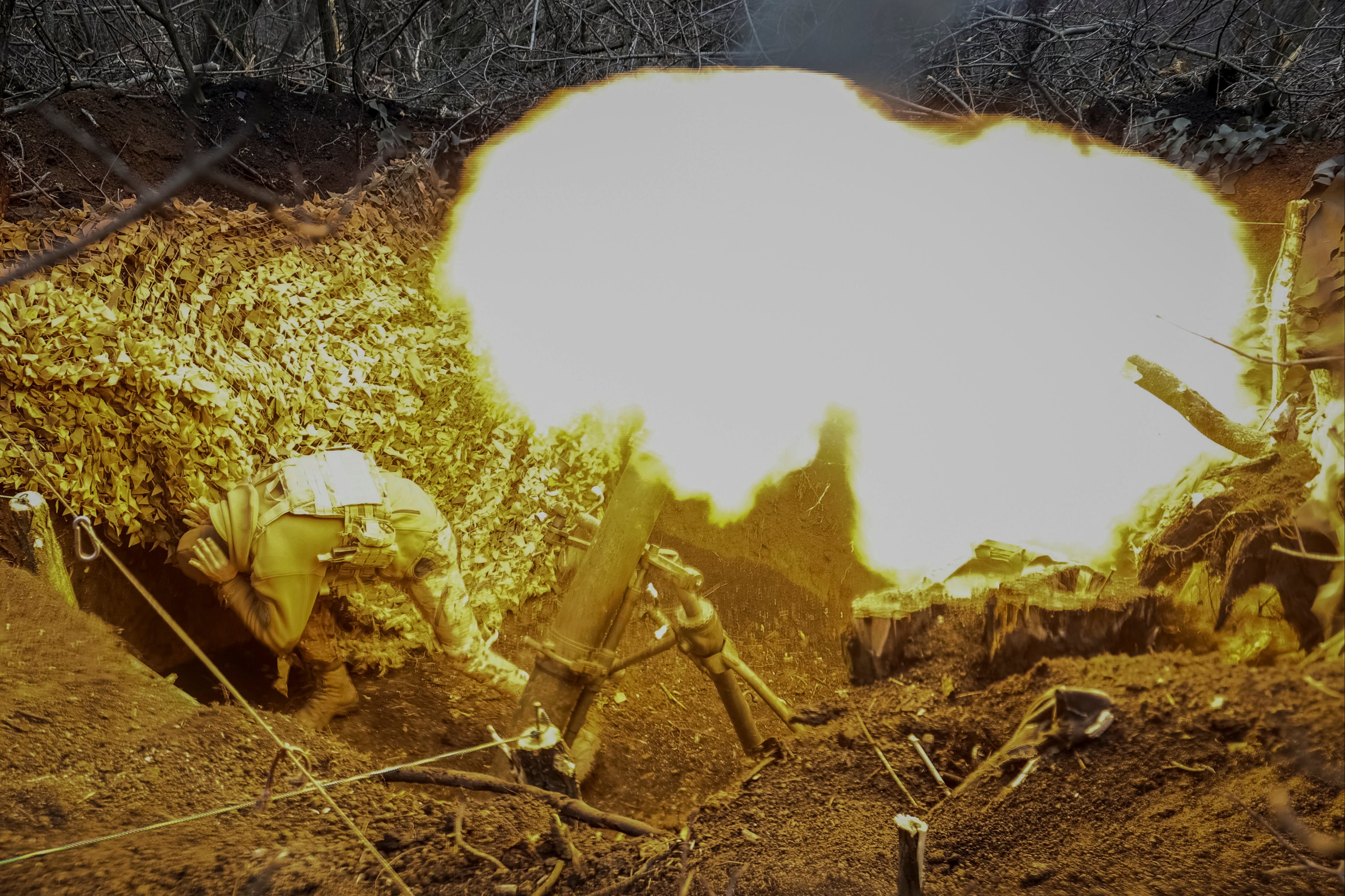 A Ukrainian serviceman of the 28th Separate Mechanized Brigade fires a 120-mm mortar towards Russian troops on a frontline in eastern Ukraine