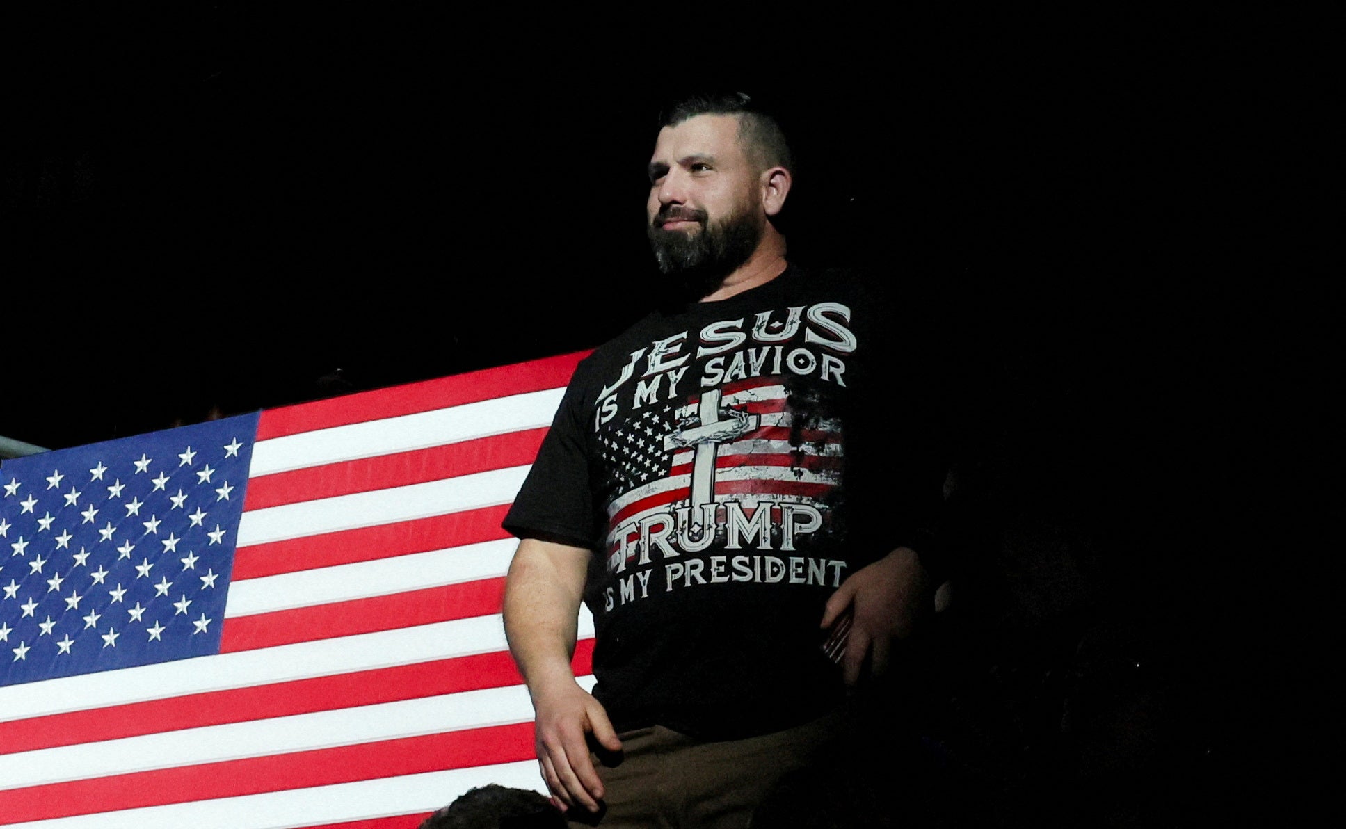 A supporter stands as former US President and Republican presidential candidate Donald Trump speaks during the National Rifle Association (NRA) Presidential Forum at the Pennsylvania Farm Show Complex & Expo Center, in Harrisburg, Pennsylvania,