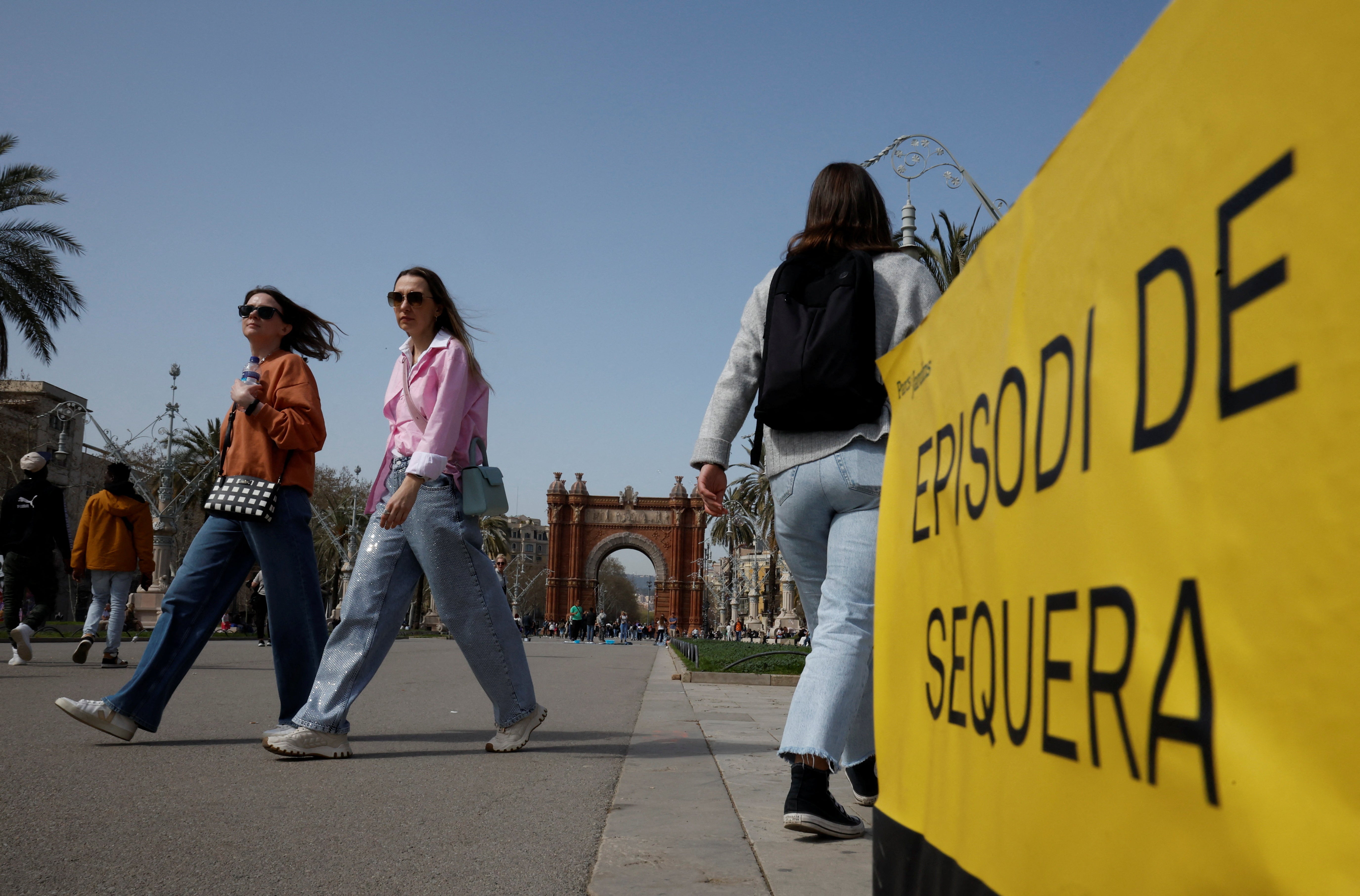 People walk past a ‘drought episode’ placard at Passeig Lluis Companys promenade in Barcelona, Spain, March 19