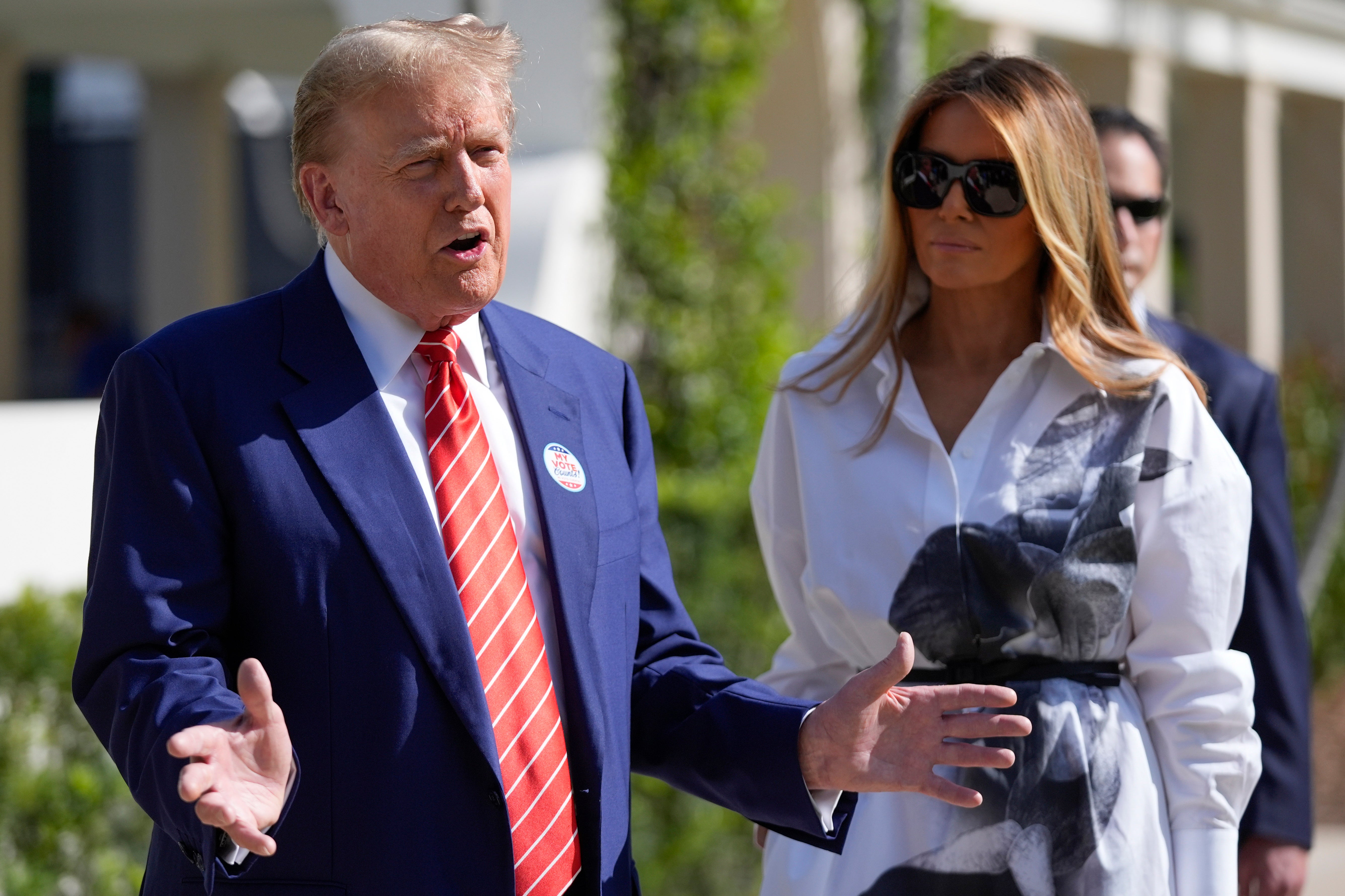 Donald Trump and Melania Trump speak to the press after voting in the Florida primary election in Palm Beach on March 19.