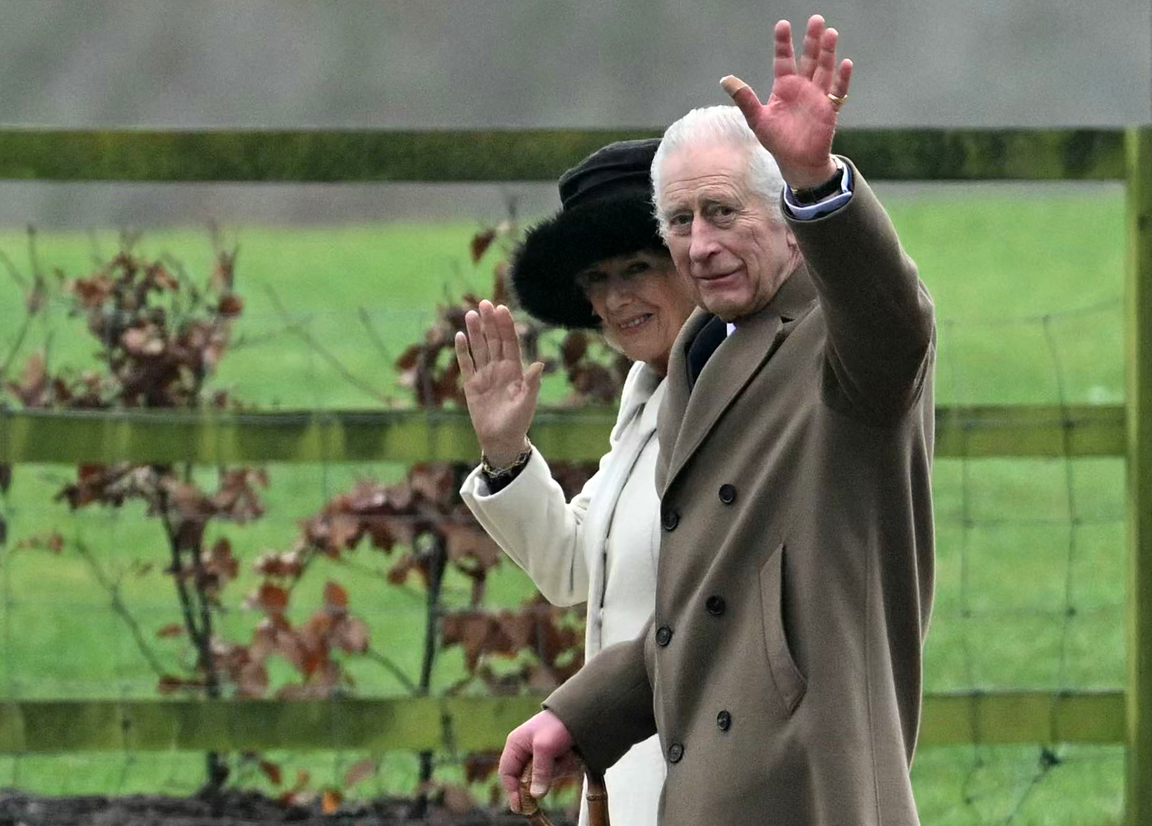 King Charles and Queen Camilla wave to well-wishers after leaving a church service in Sandringham on February 11