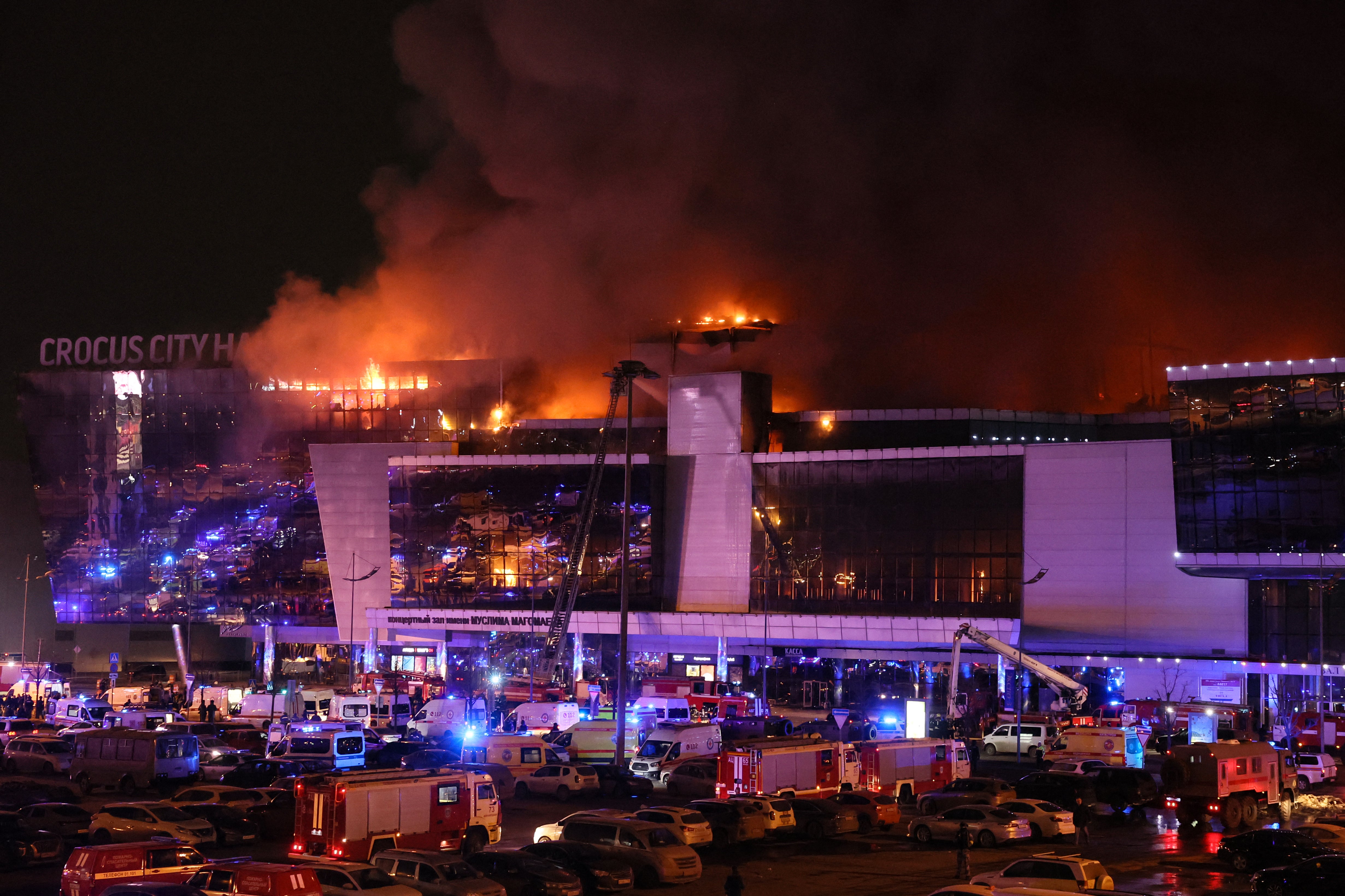 Emergency services vehicles are seen outside the burning Crocus City Hall concert hall following the shooting incident in Krasnogorsk, outside Moscow, on March 22, 2024