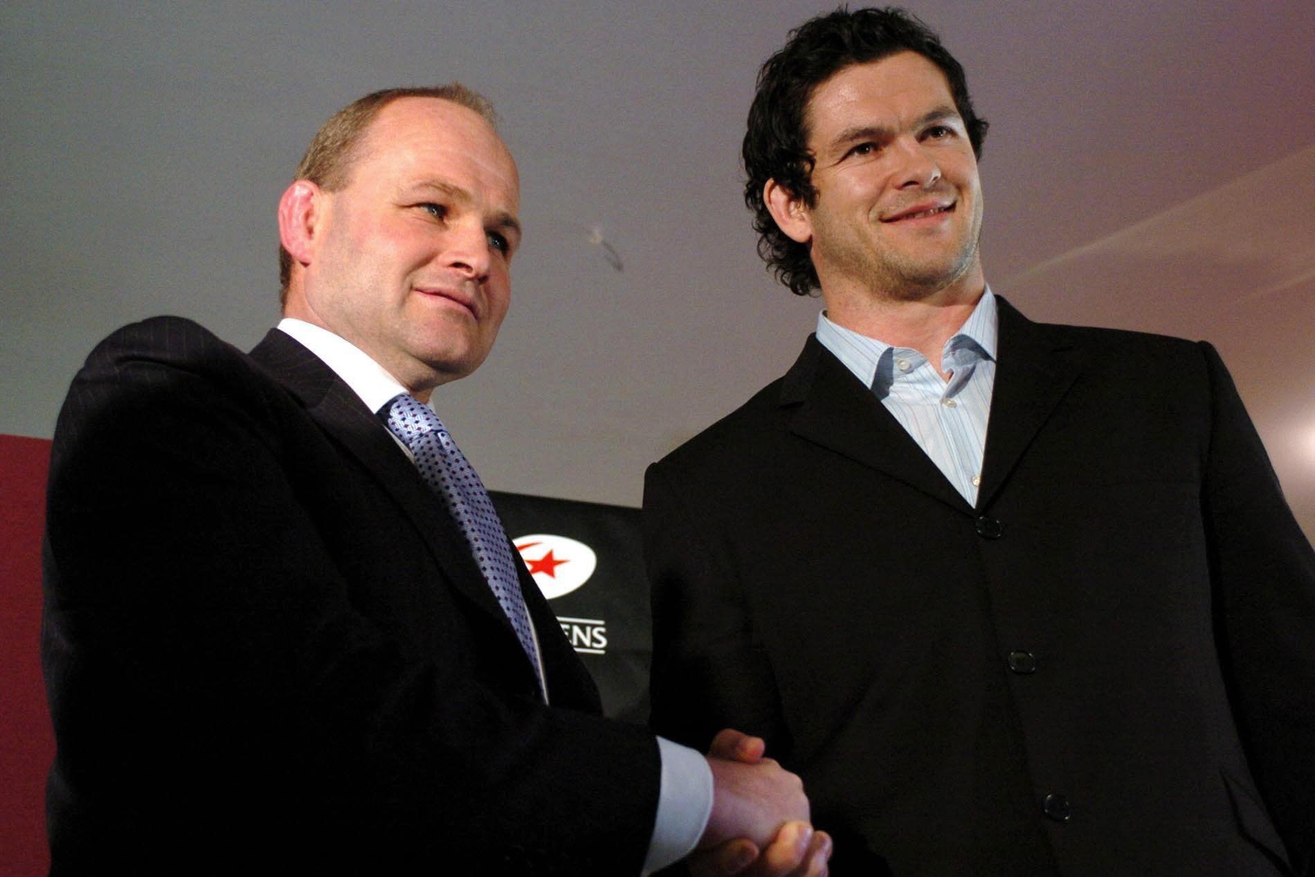 Andy Farrell, right, shakes hands with England head coach Andy Robinson after signing for Saracens in 2005 (Chris Radburn/PA)