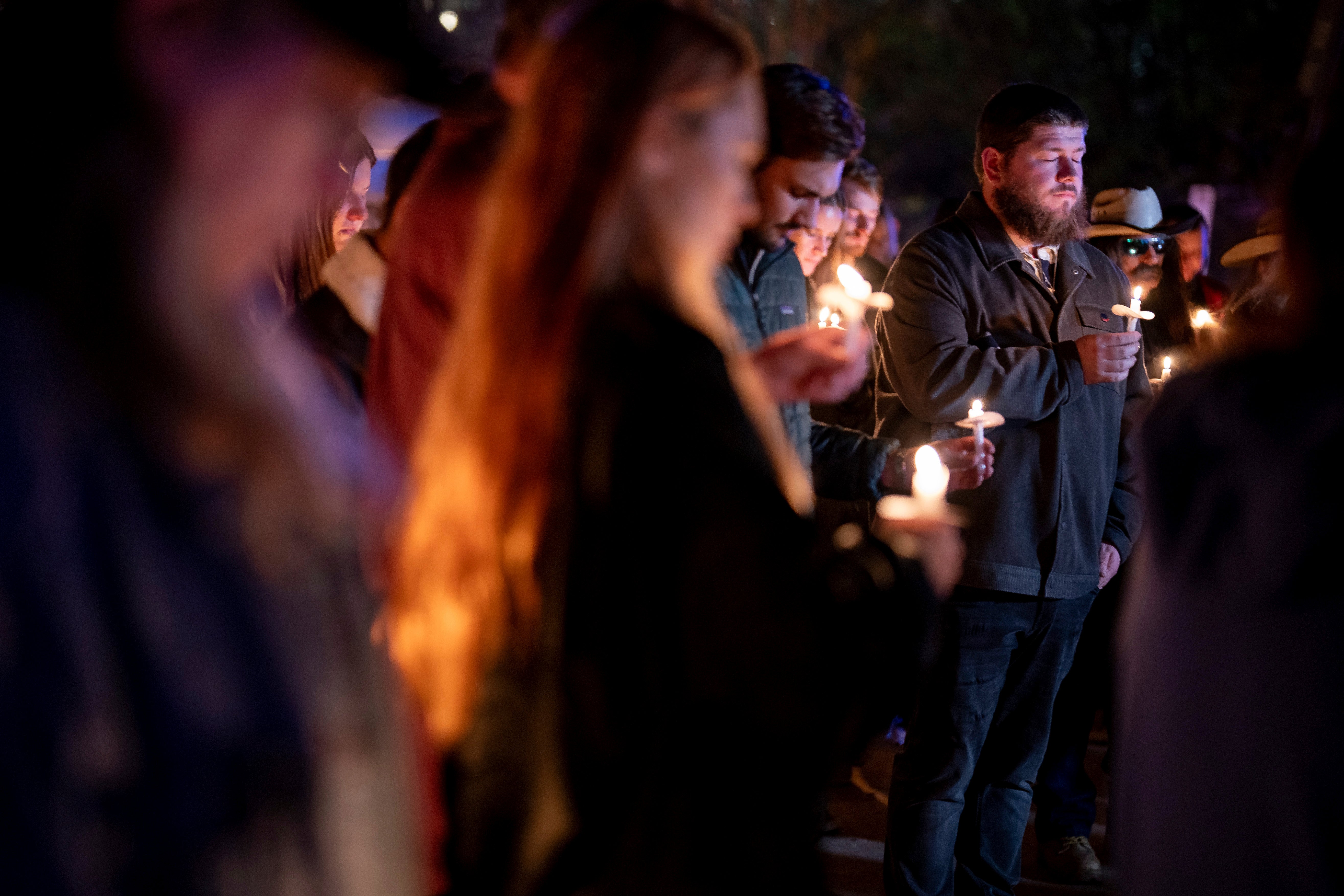 People gather and hold candles at a vigil for Riley Strain just hours after police announced his body was recovered