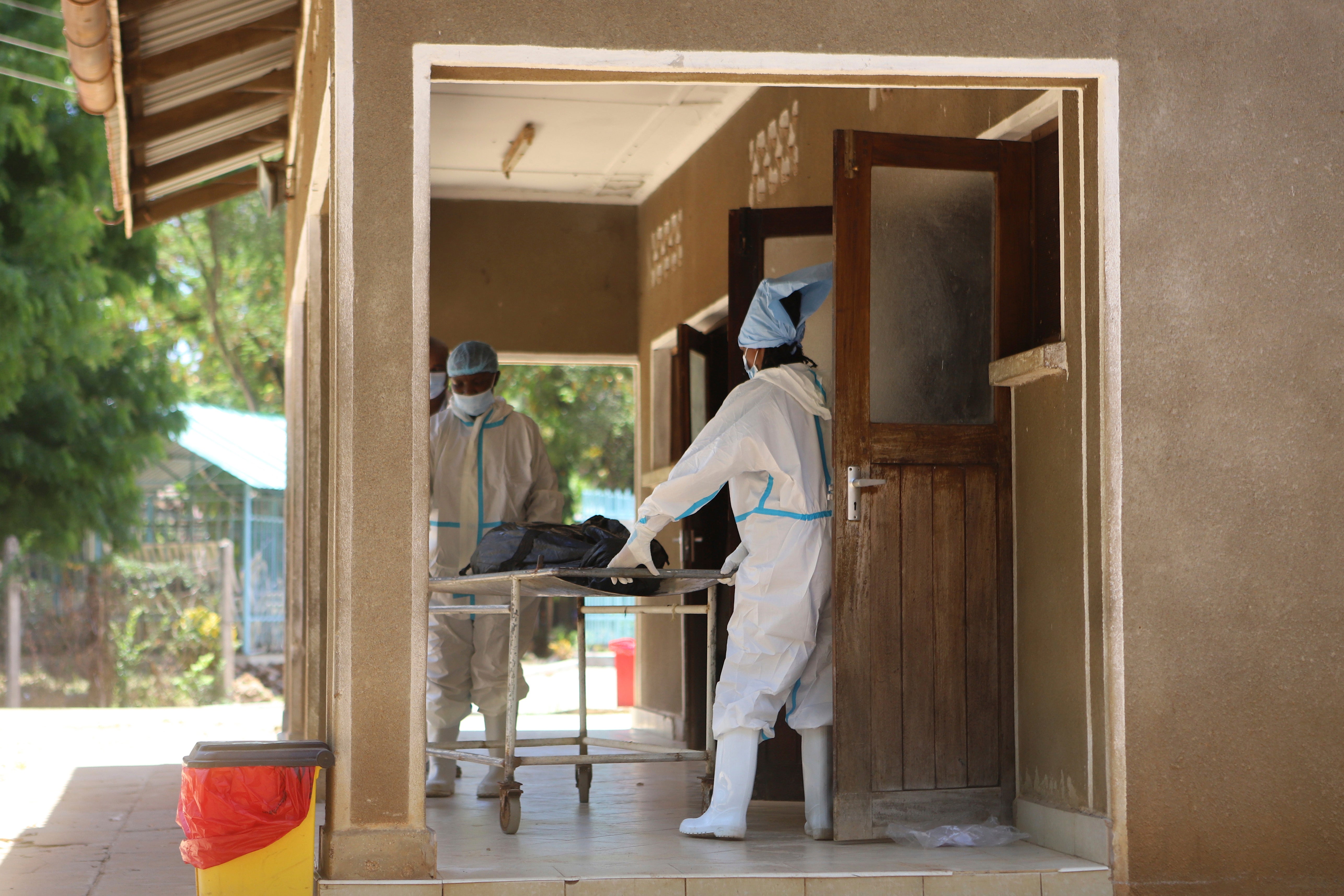 Morgue workers move a body of a victim of a religious cult for burial in Malindi Funeral home in Kilifi, Kenya