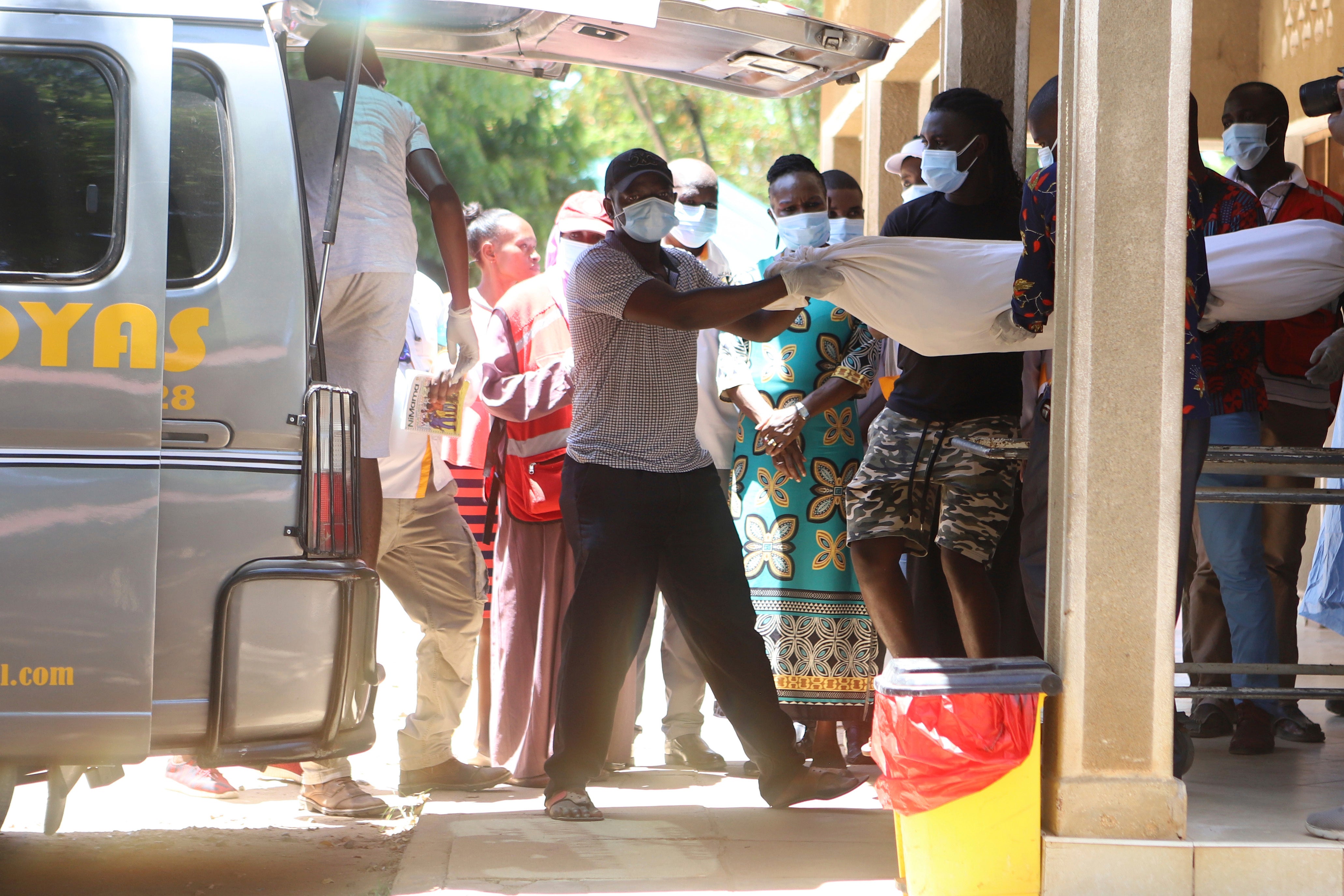 Family members carry a body of victim of a religious cult for burial in Malindi Funeral home in Kilifi, Kenya