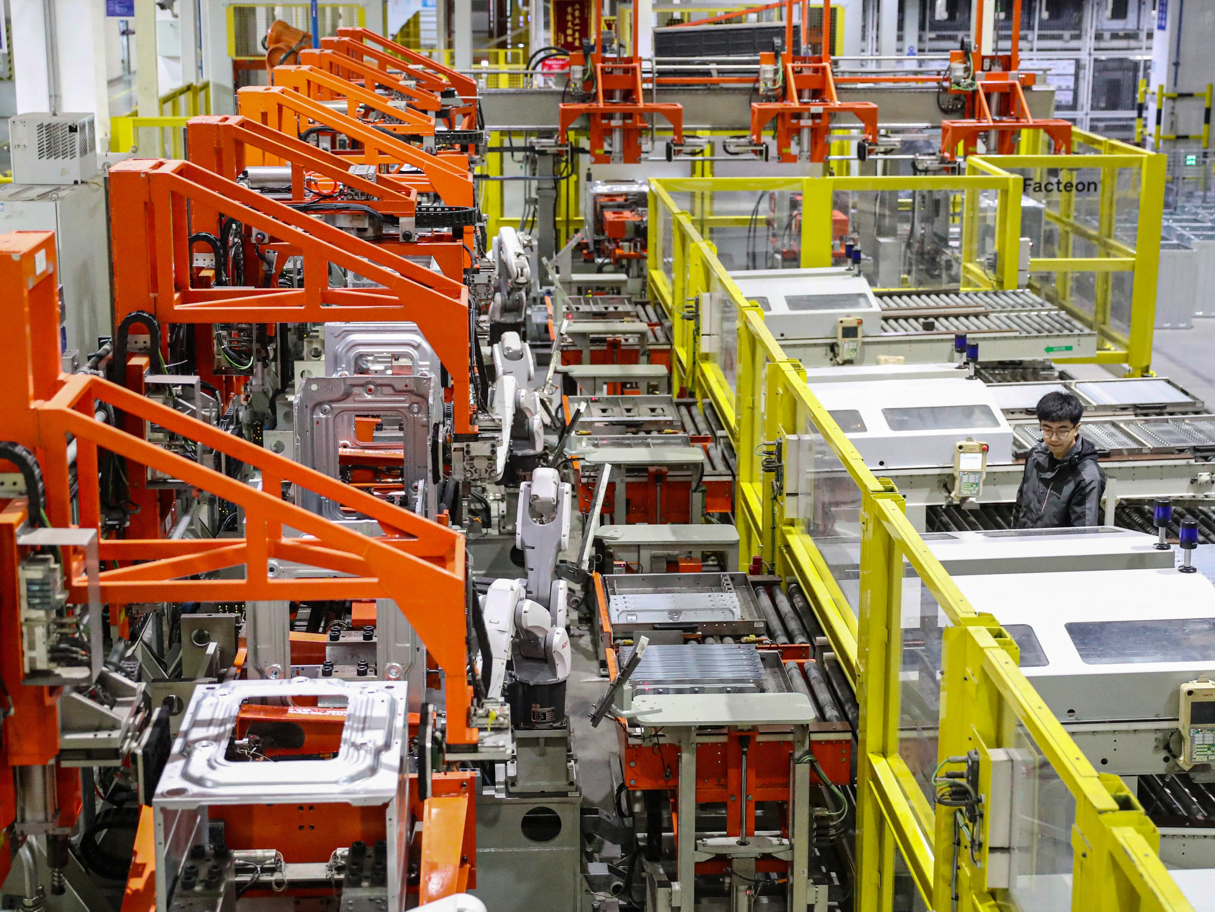 Employees work on a washing machine production line at a factory in Qingdao