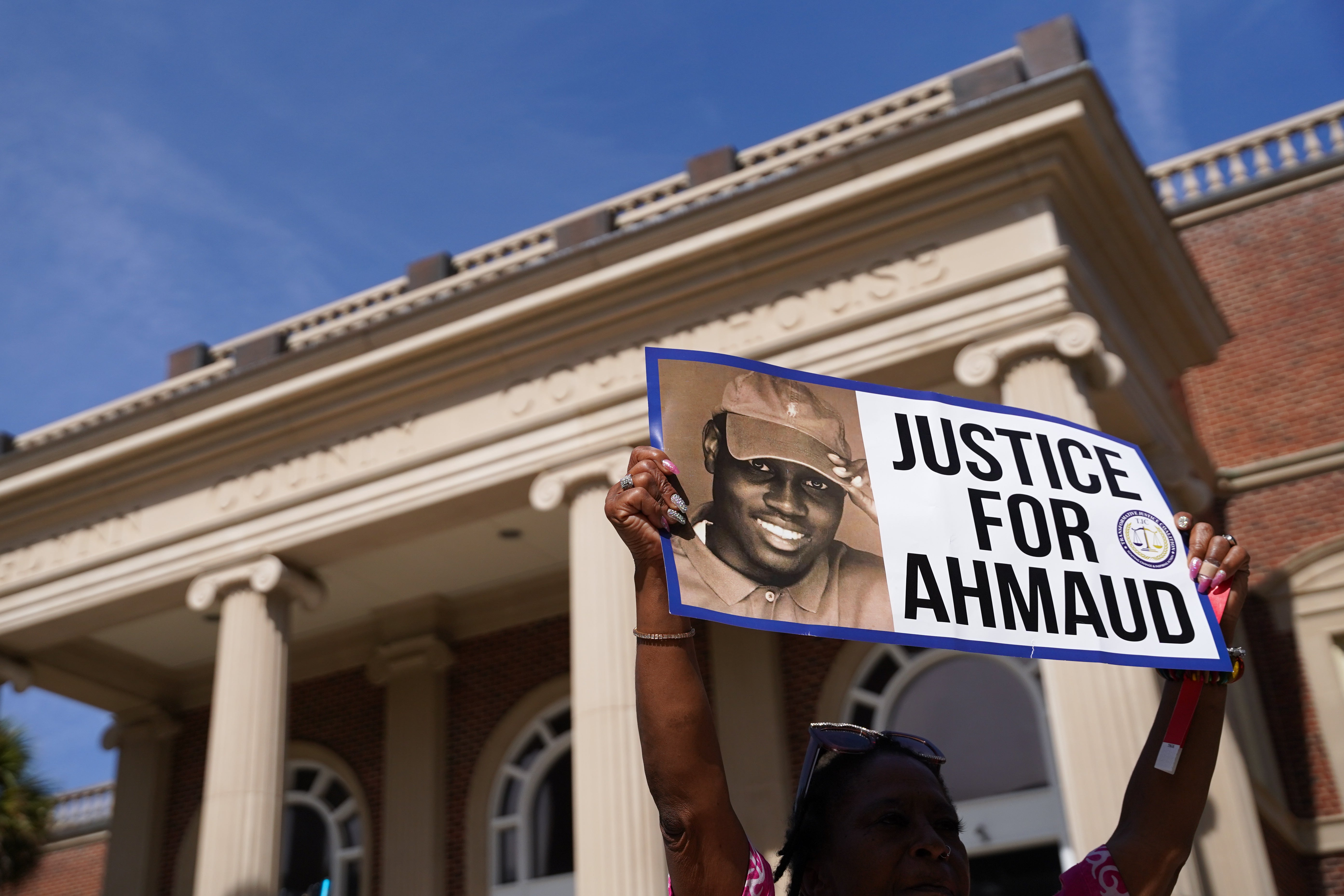 A demonstrator holds a sign that reads, “Justice for Ahmaud” after three men murdered Ahmaud Arbery while he was on a jog in their neighbourhood