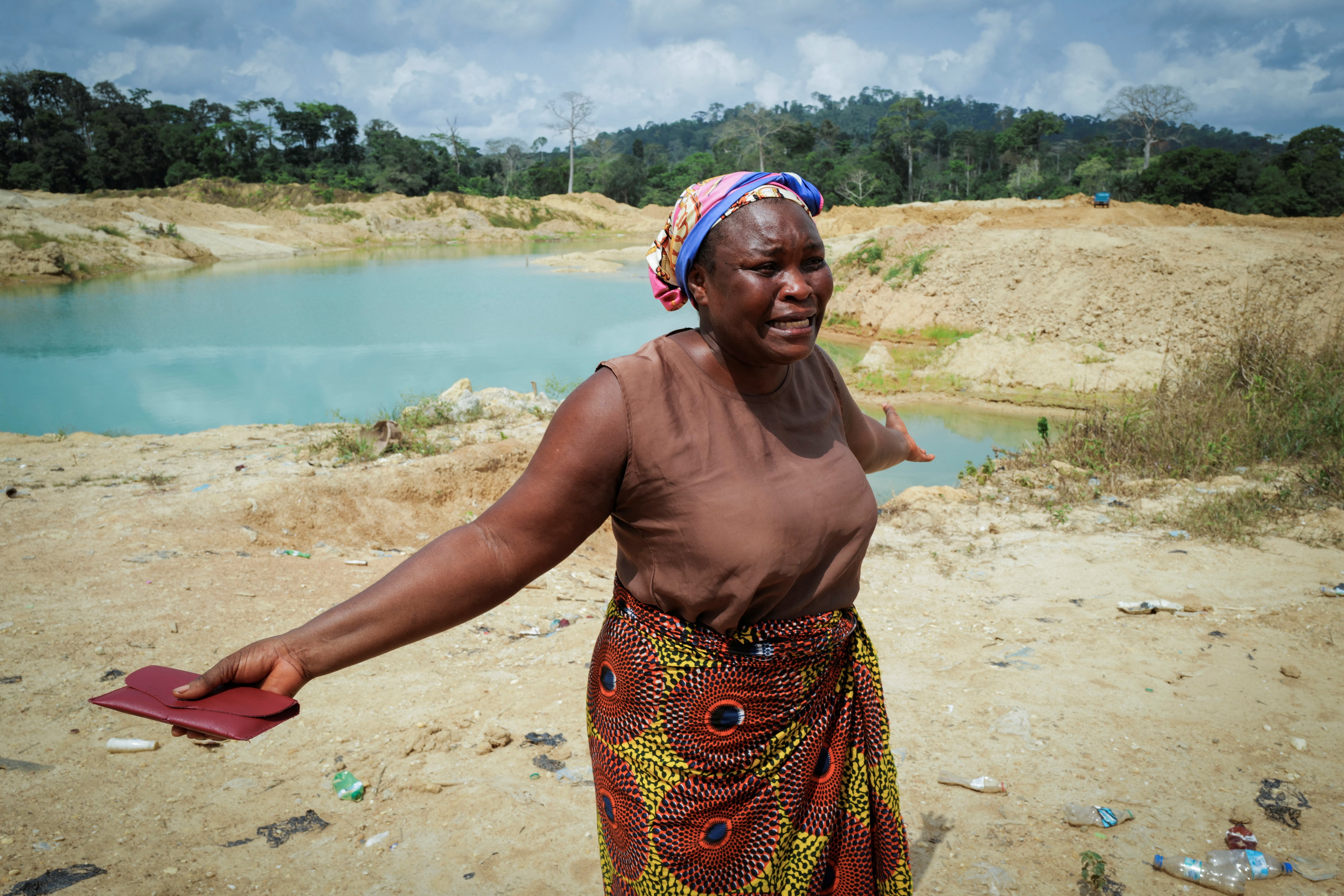 Janet Gyamfi, 52, a cocoa farmer in Ghana, weeps at her plantation which was destroyed by illegal gold mining