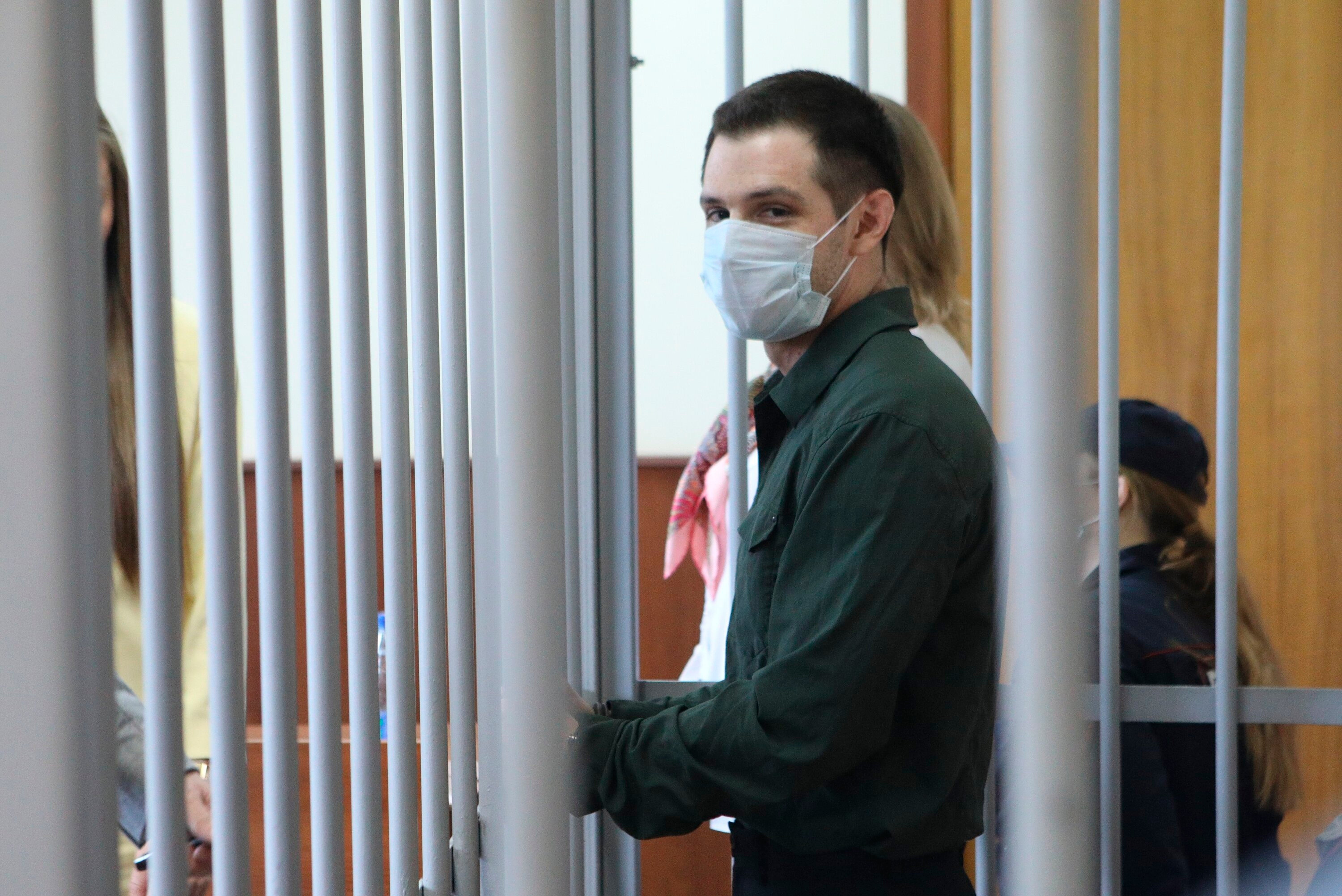 US Marine veteran Trevor Reed stands behind bars in a courtroom in Moscow, Russia, on Monday, July 20, 2020