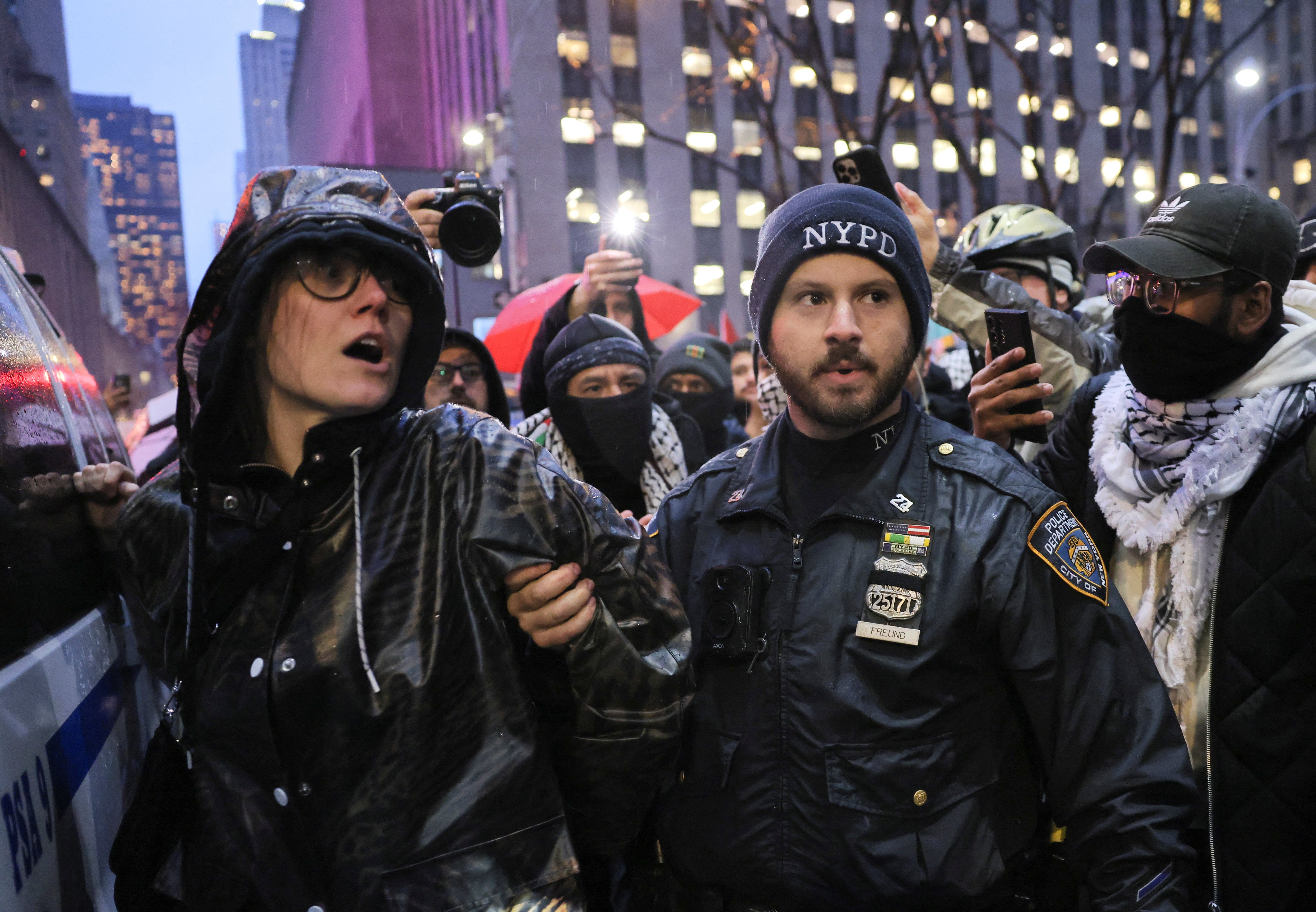 A protester is detained outside the venue