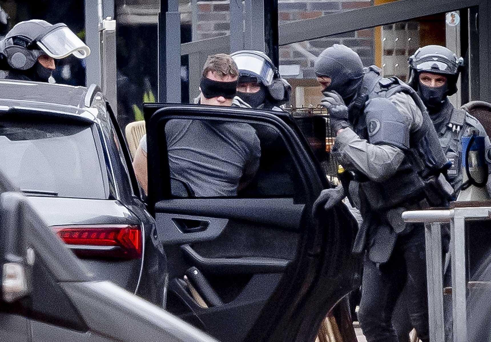 A man (C) is detained by the Special Intervention Service (DSI) of the Dutch National Police Corps outside a cafe in the center of Ede