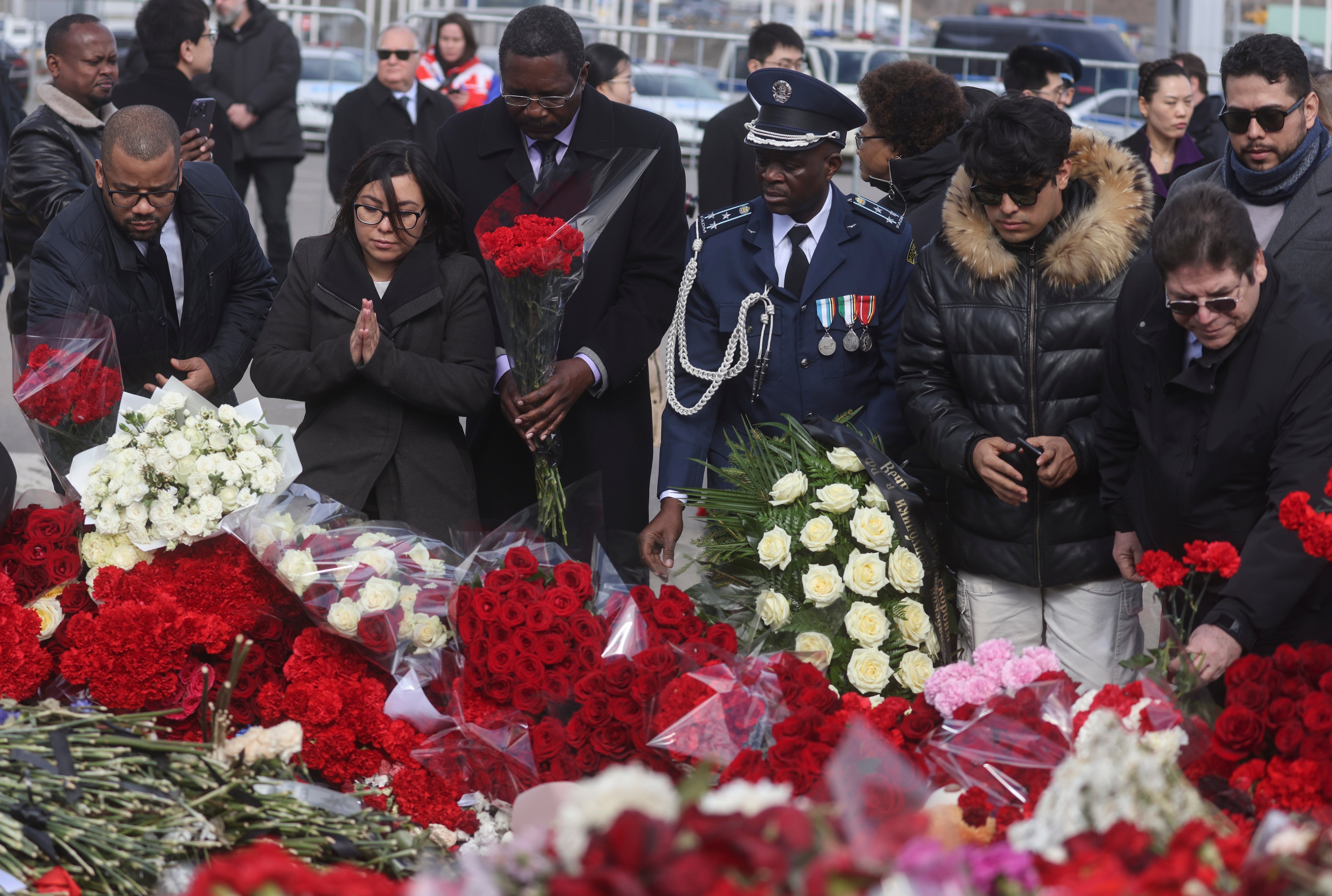 A group of ambassadors of foreign diplomatic missions attend a laying ceremony at a makeshift memorial in front of the Crocus City Hall