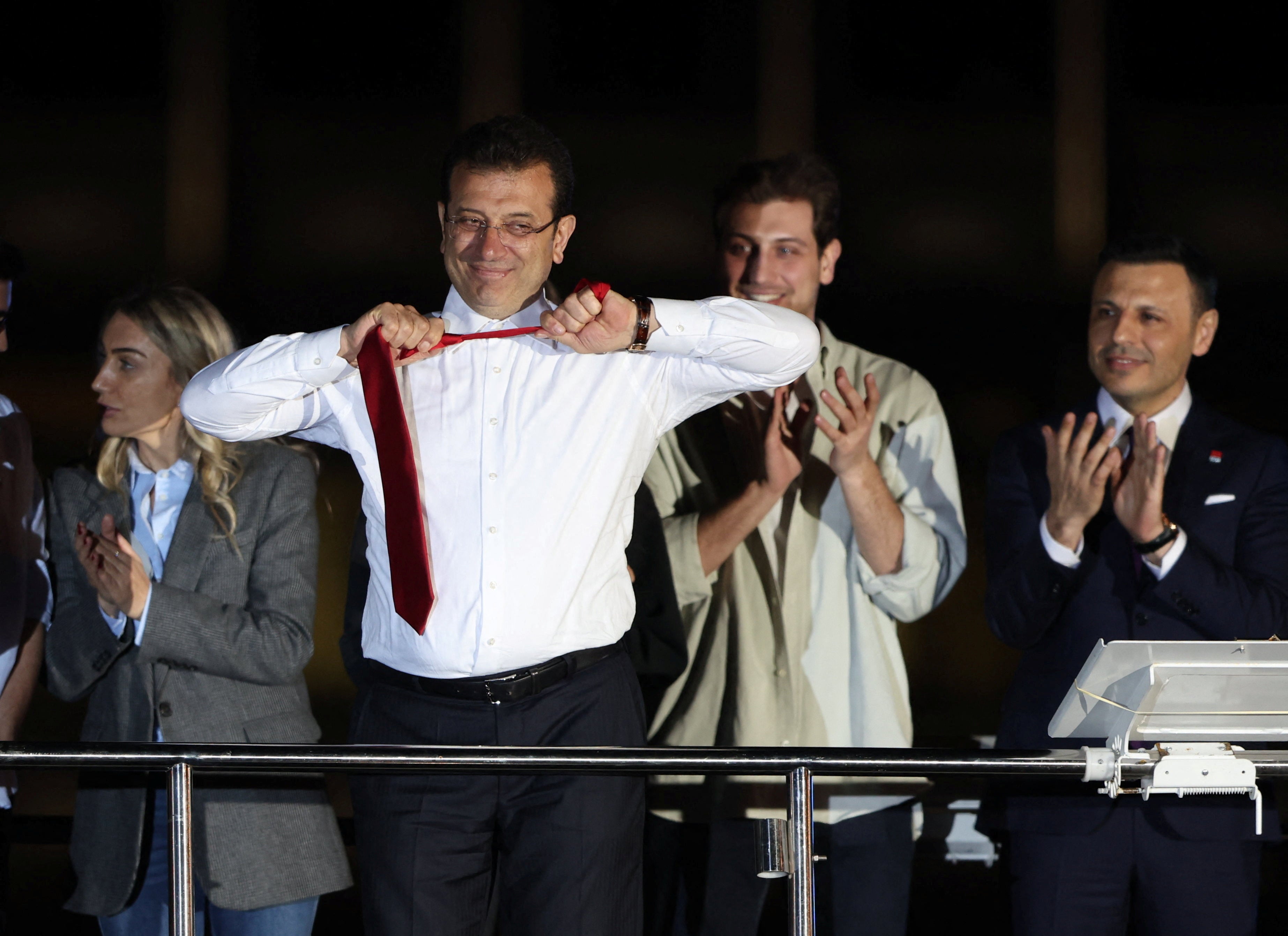 Ekrem Imamoglu, mayoral candidate of the main opposition CHP, takes off his tie as he addresses his supporters