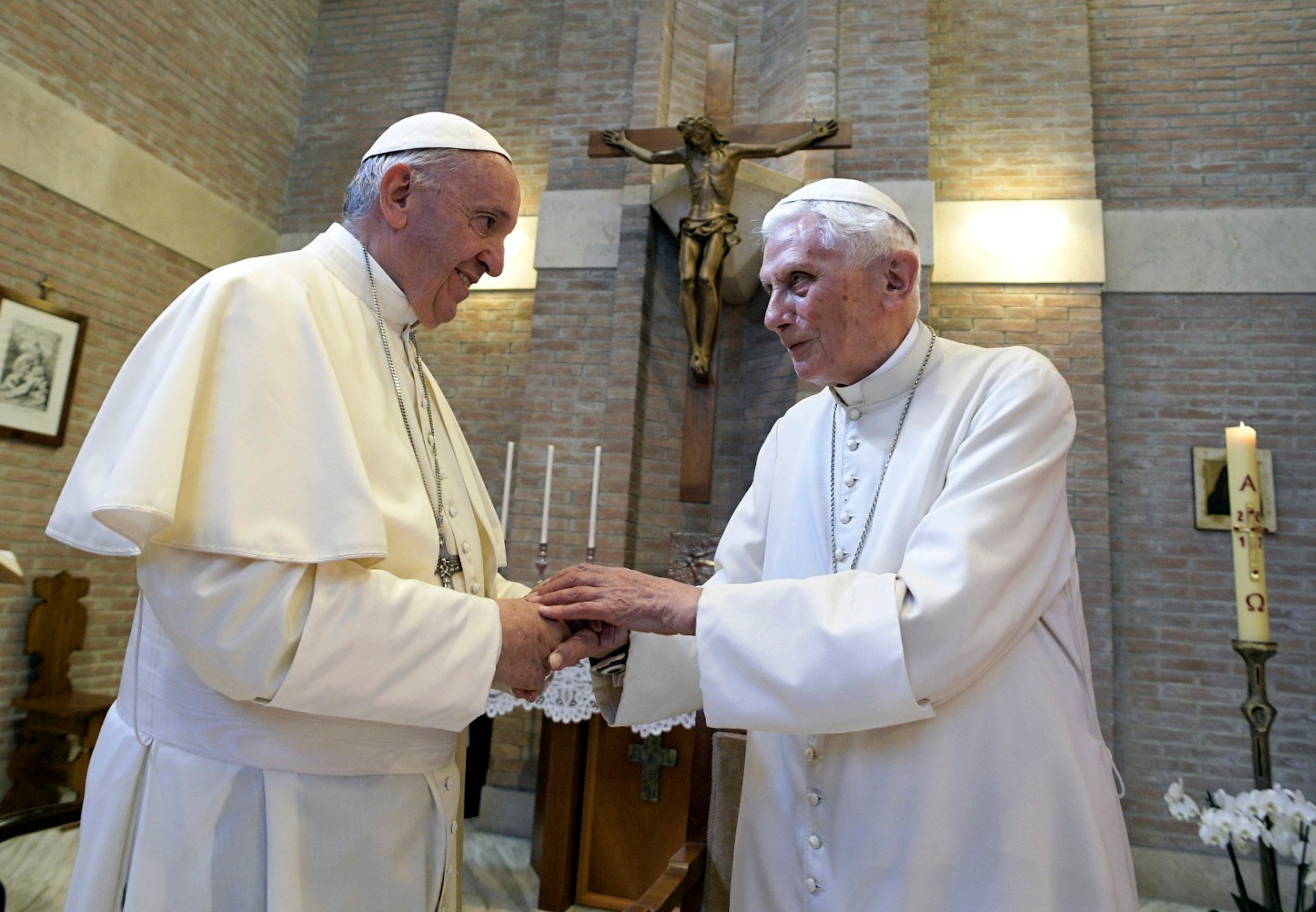 FILE - Pope Francis, left, and Pope Benedict XVI, meet each other on the occasion of the elevation of five new cardinals