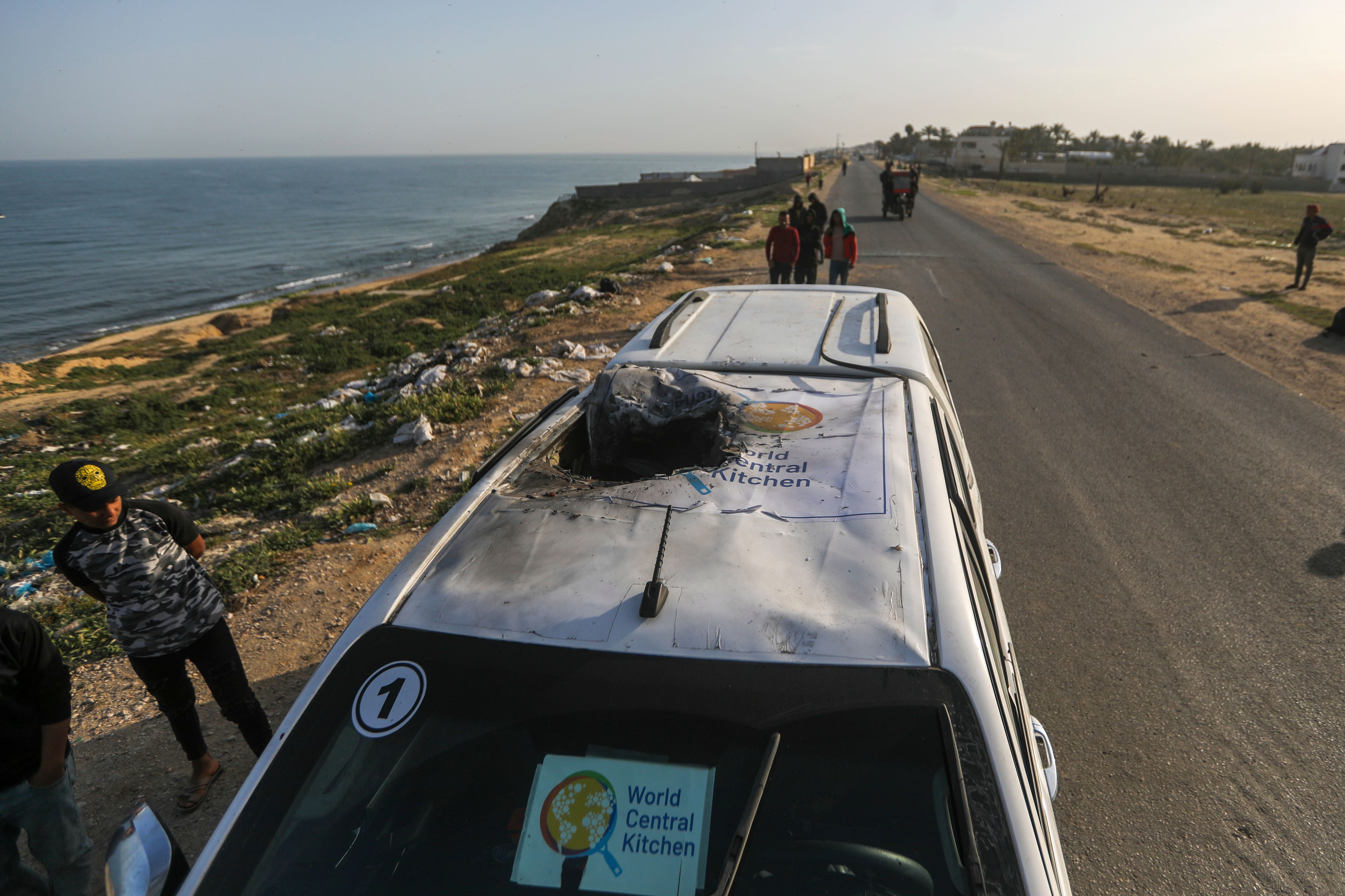 Palestinians inspect a vehicle with the logo of the World Central Kitchen wrecked by an Israeli air strike in Deir al Balah in the Gaza Strip (Ismael Abu Dayyah/AP)