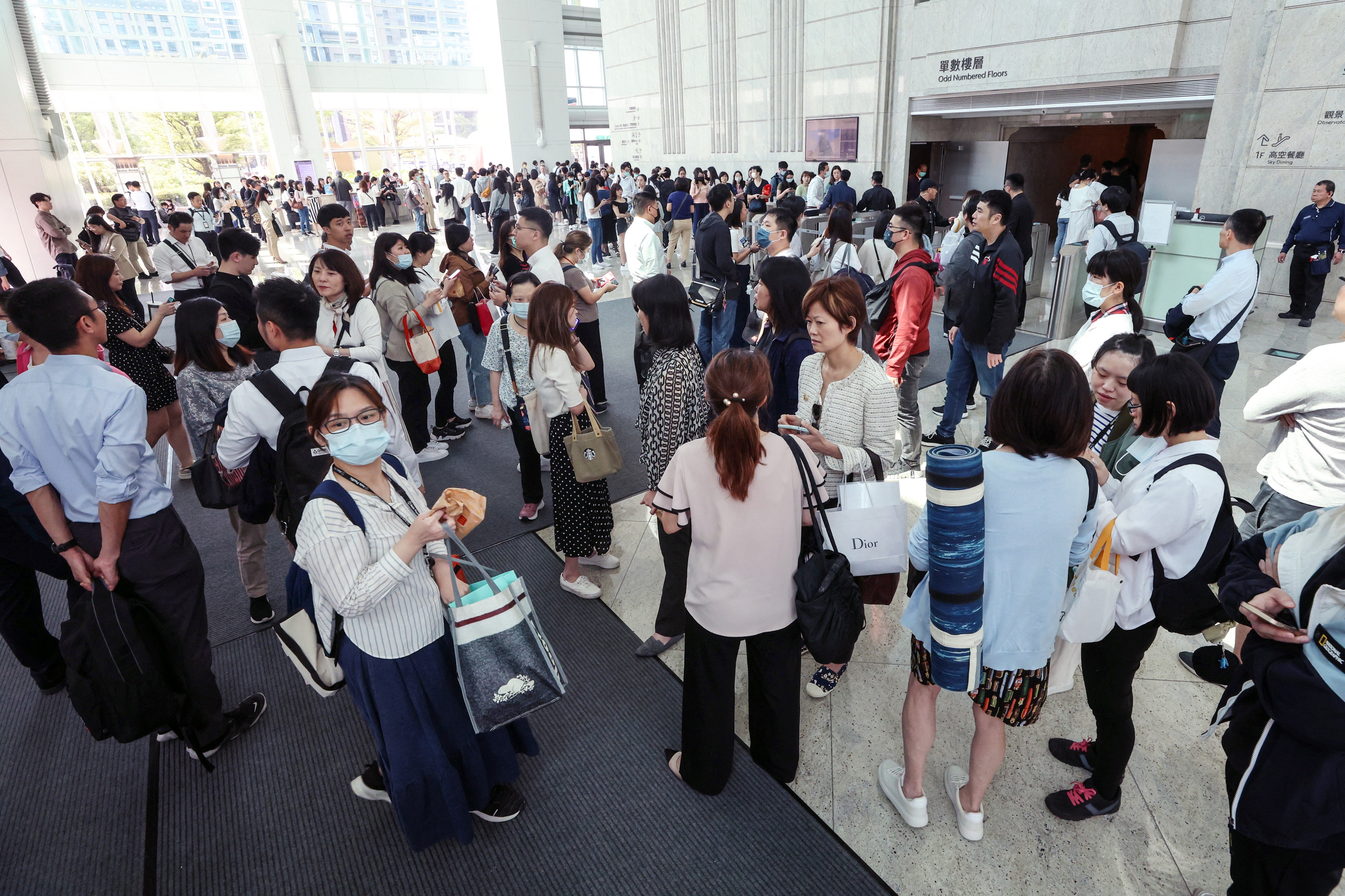 People gathering in the lobby of the Taipei 101 office building