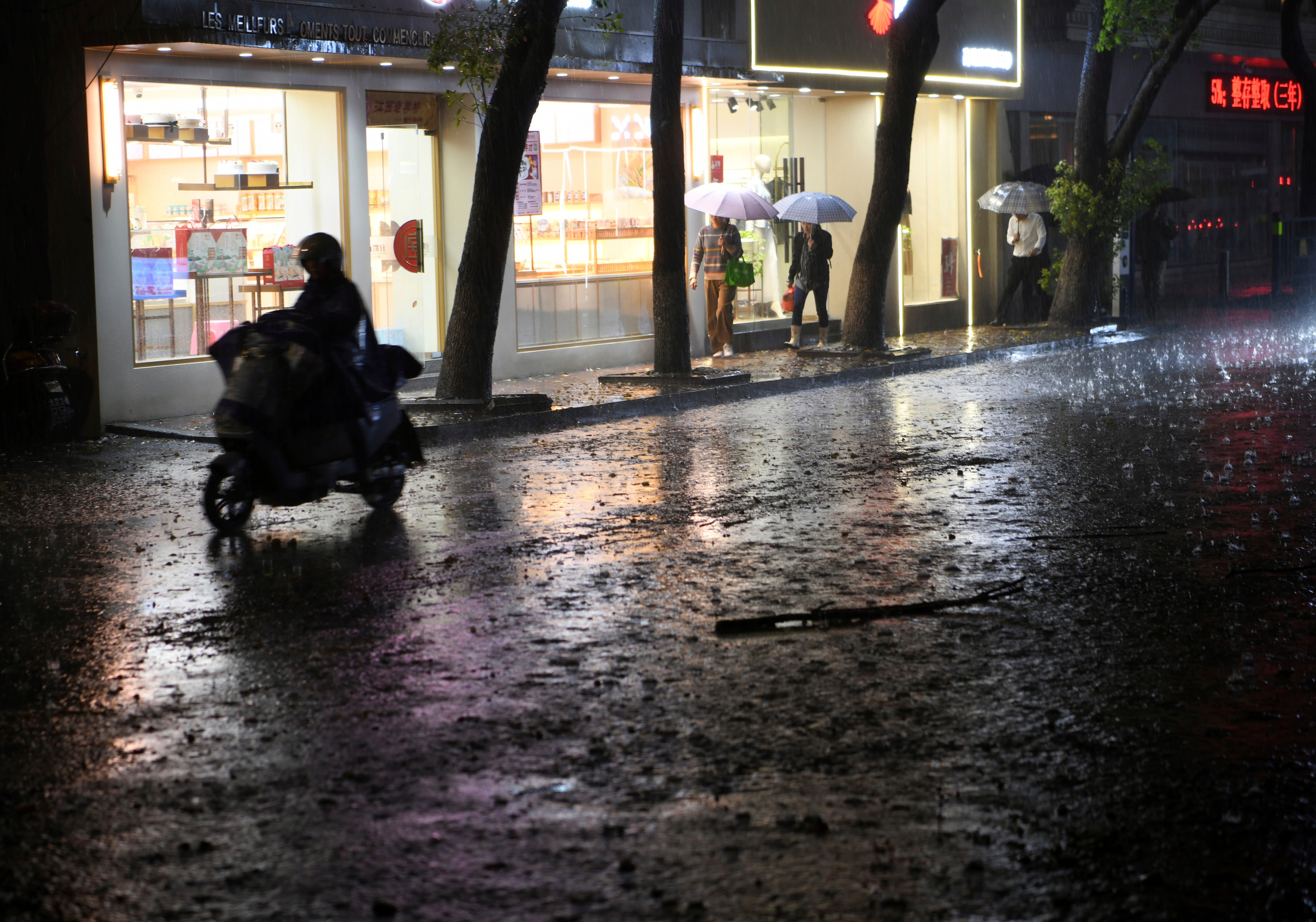 Residents pass through rain storm in Nanchang in eastern China’s Jiangxi province Tuesday, 2 April 2024