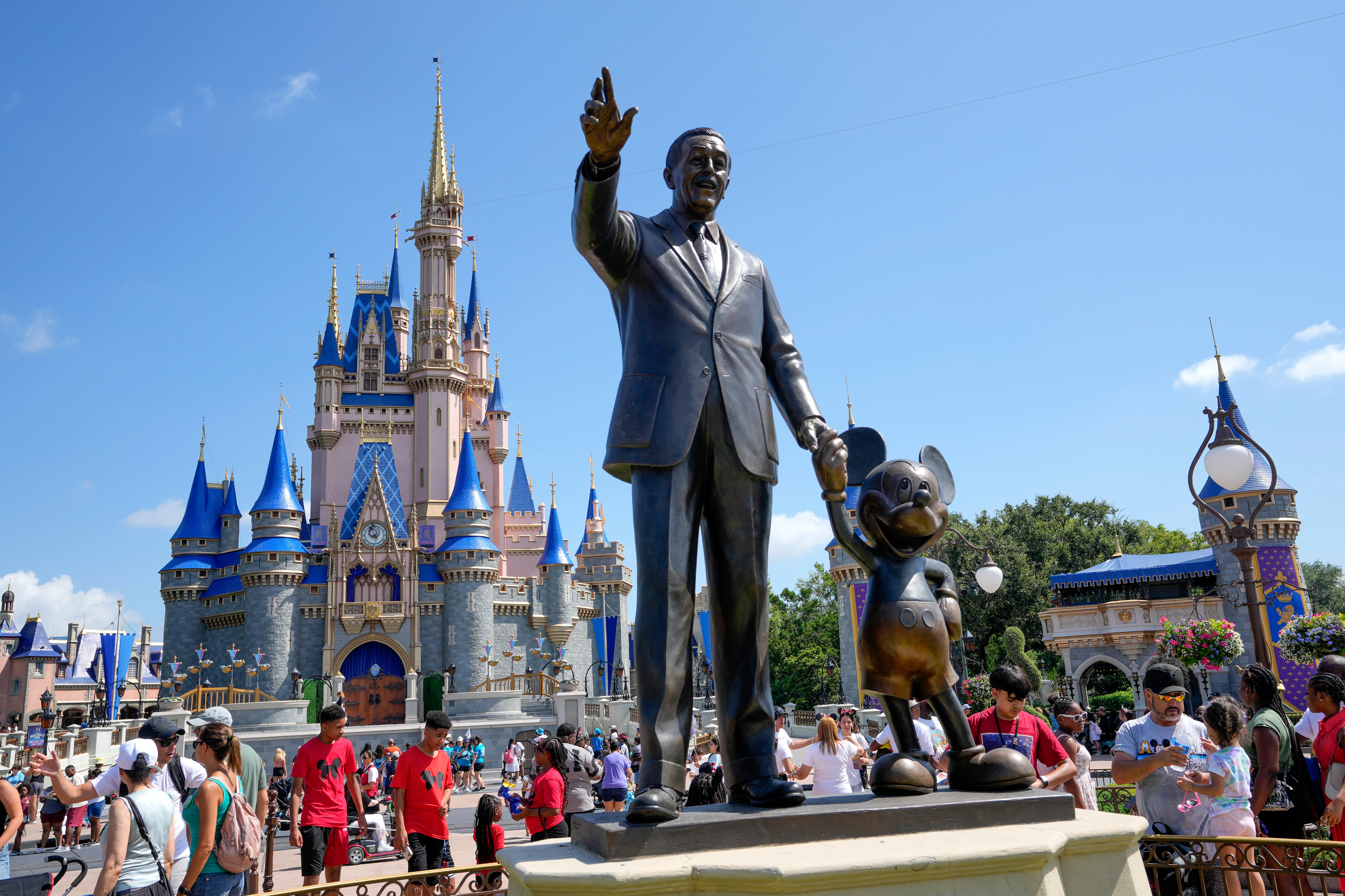 Guests pass a statue of Walt Disney and Mickey Mouse at the Magic Kingdom at Walt Disney World, in Lake Buena Vista, Florida