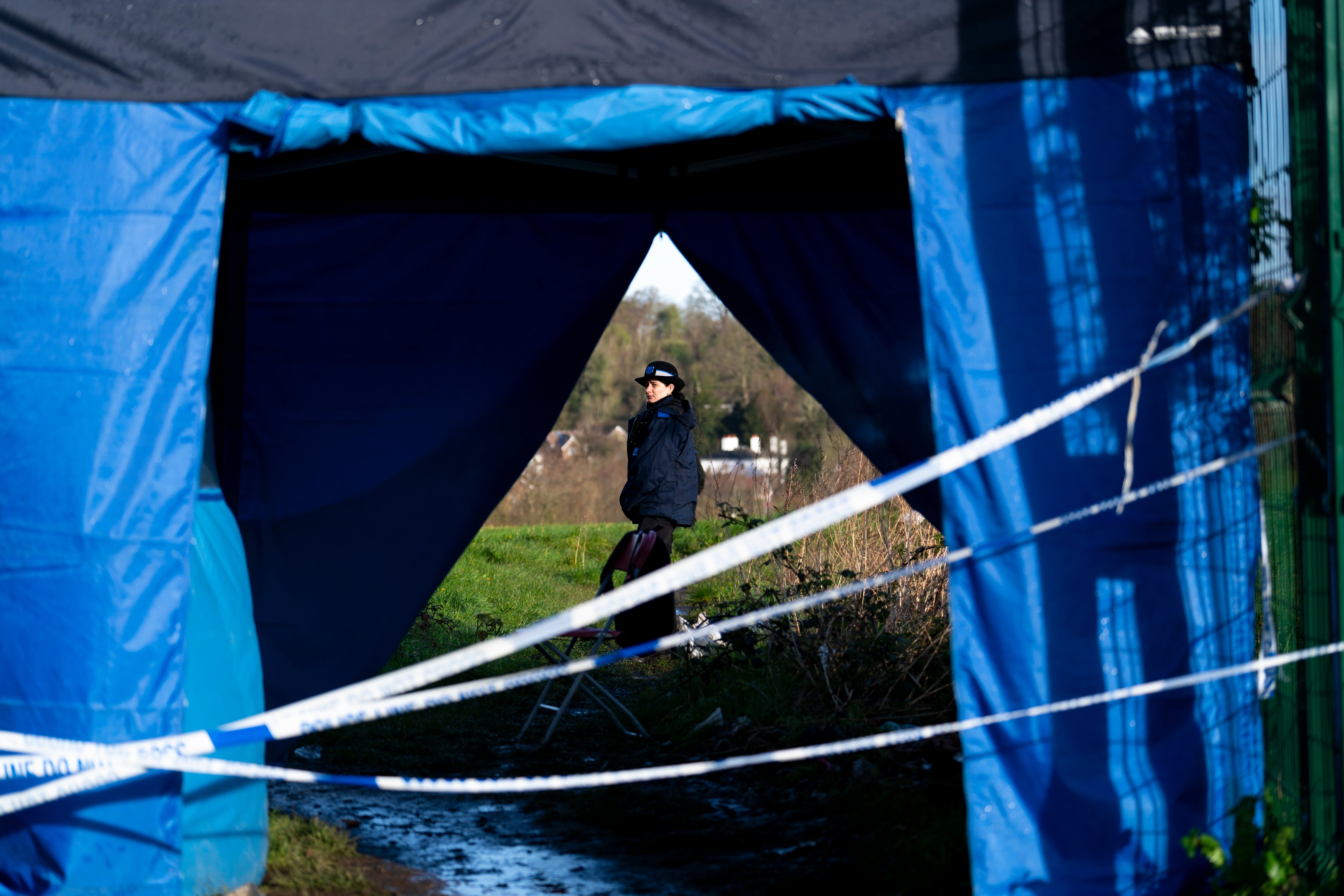 Police near the scene in Rowdown Fields, a park in Croydon, south London, where human remains were found