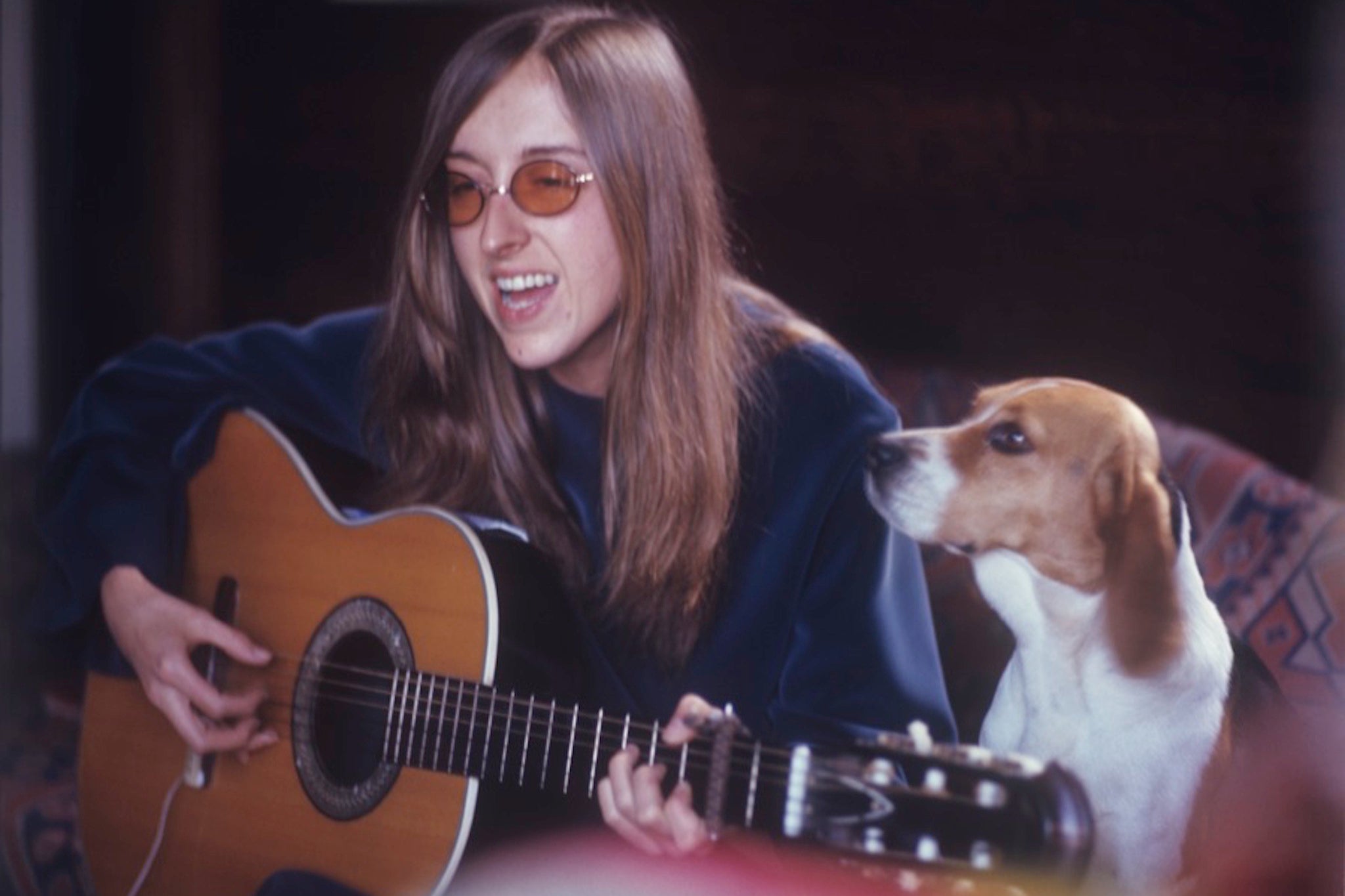 Judee Sill pictured with a guitar and dog