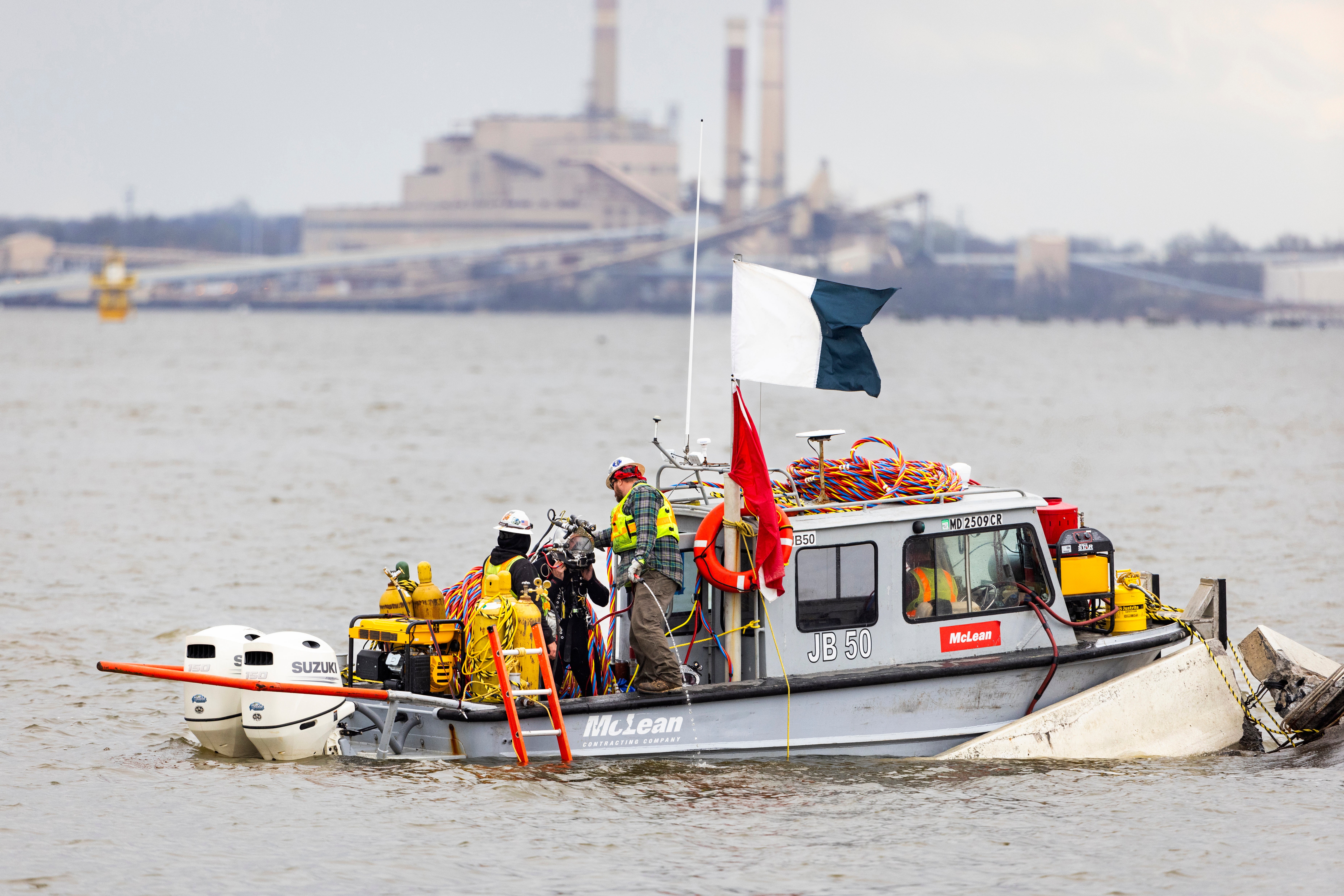 A dive crew prepares to send a diver beneath the water surrounding the collapsed Francis Scott Key Bridge in Baltimore, Maryland