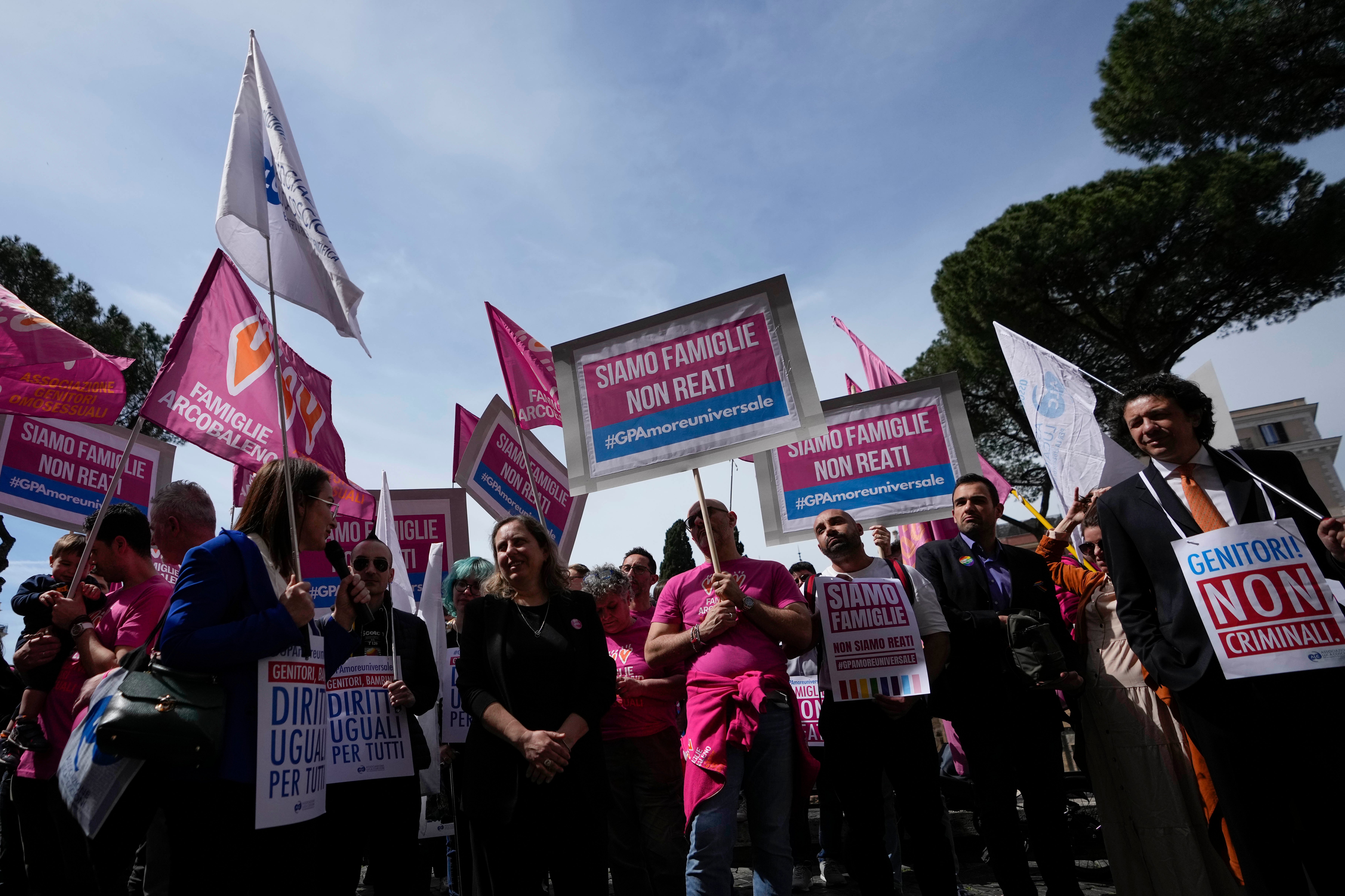 People hold banners reading ‘we are families not crimes’ during a pro-surrogacy flash-mob in Rome