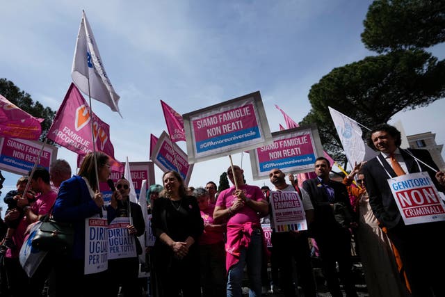 <p>People hold banners reading  ‘we are families not crimes’ during a pro-surrogacy flash-mob in Rome</p>