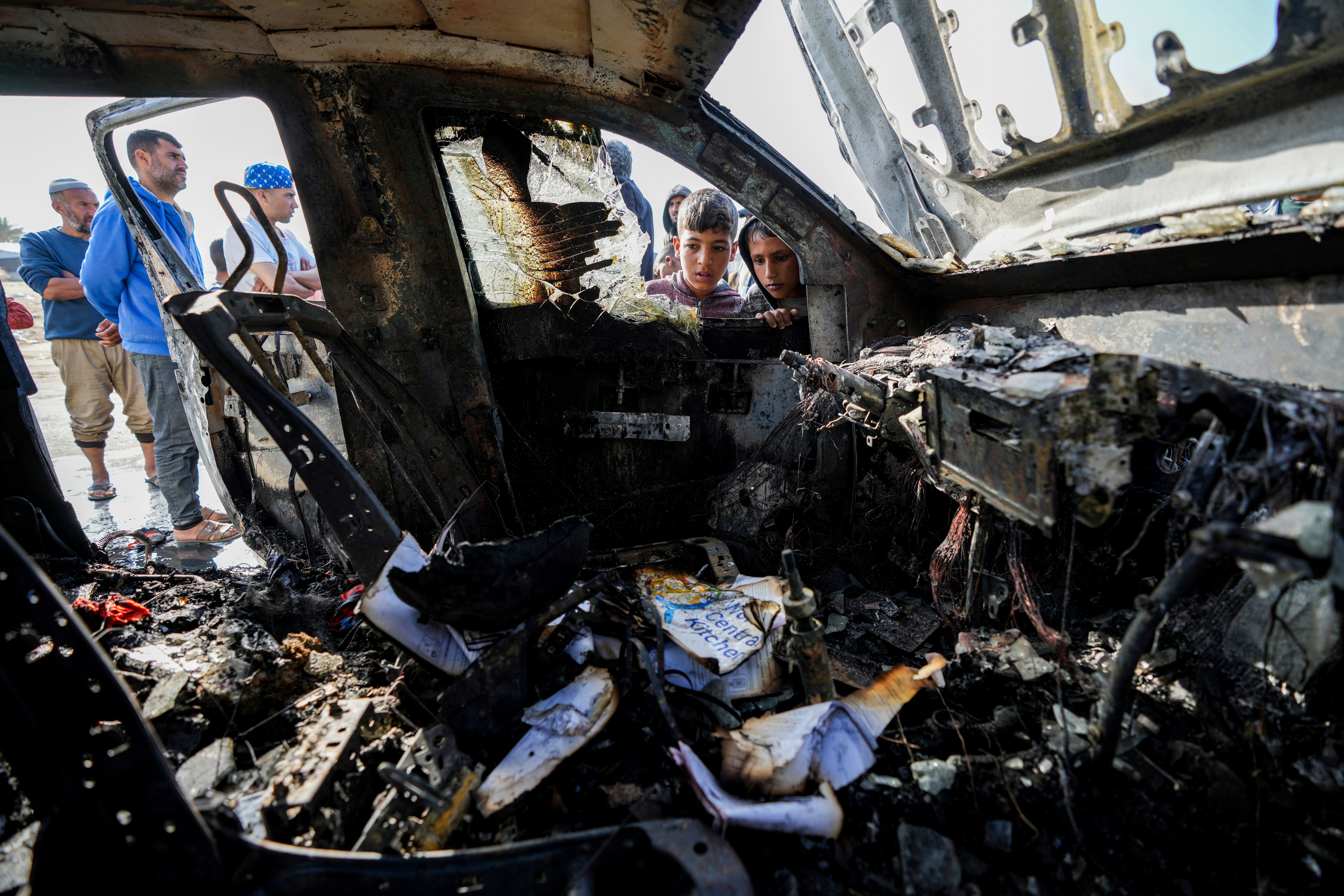 People inspect the site where World Central Kitchen workers were killed in Deir al-Balah, Gaza Strip, Tuesday, April 2, 2024