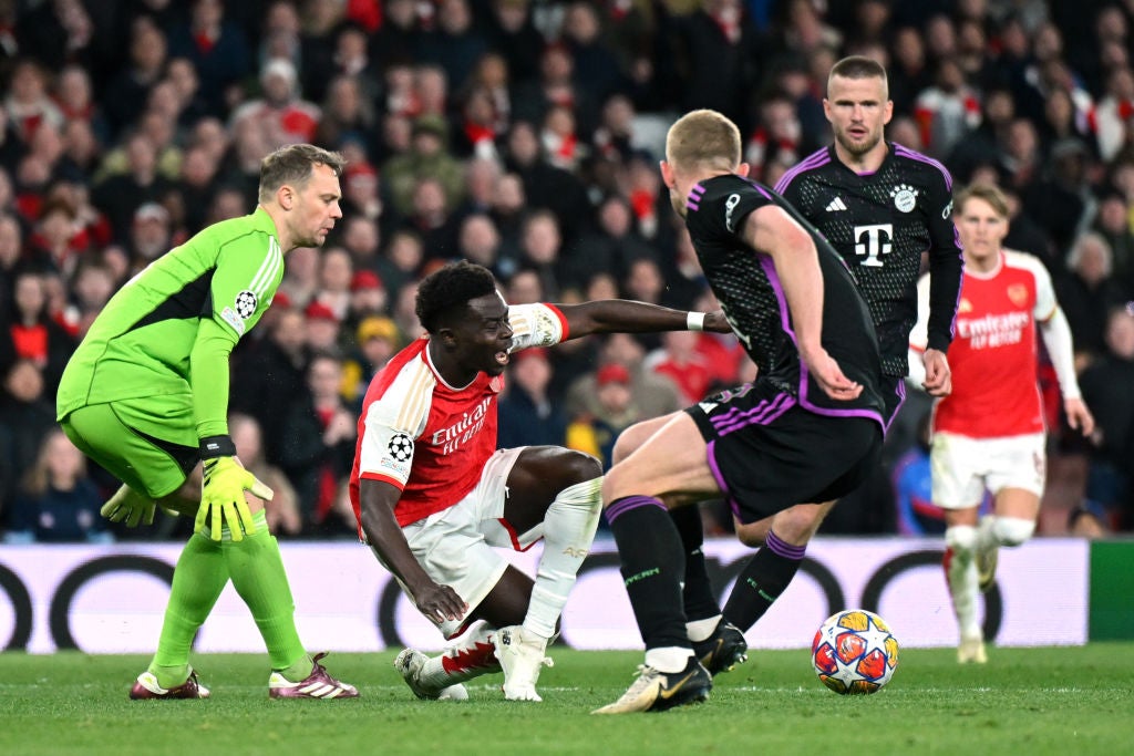 Saka goes down in the box after a collision with Neuer