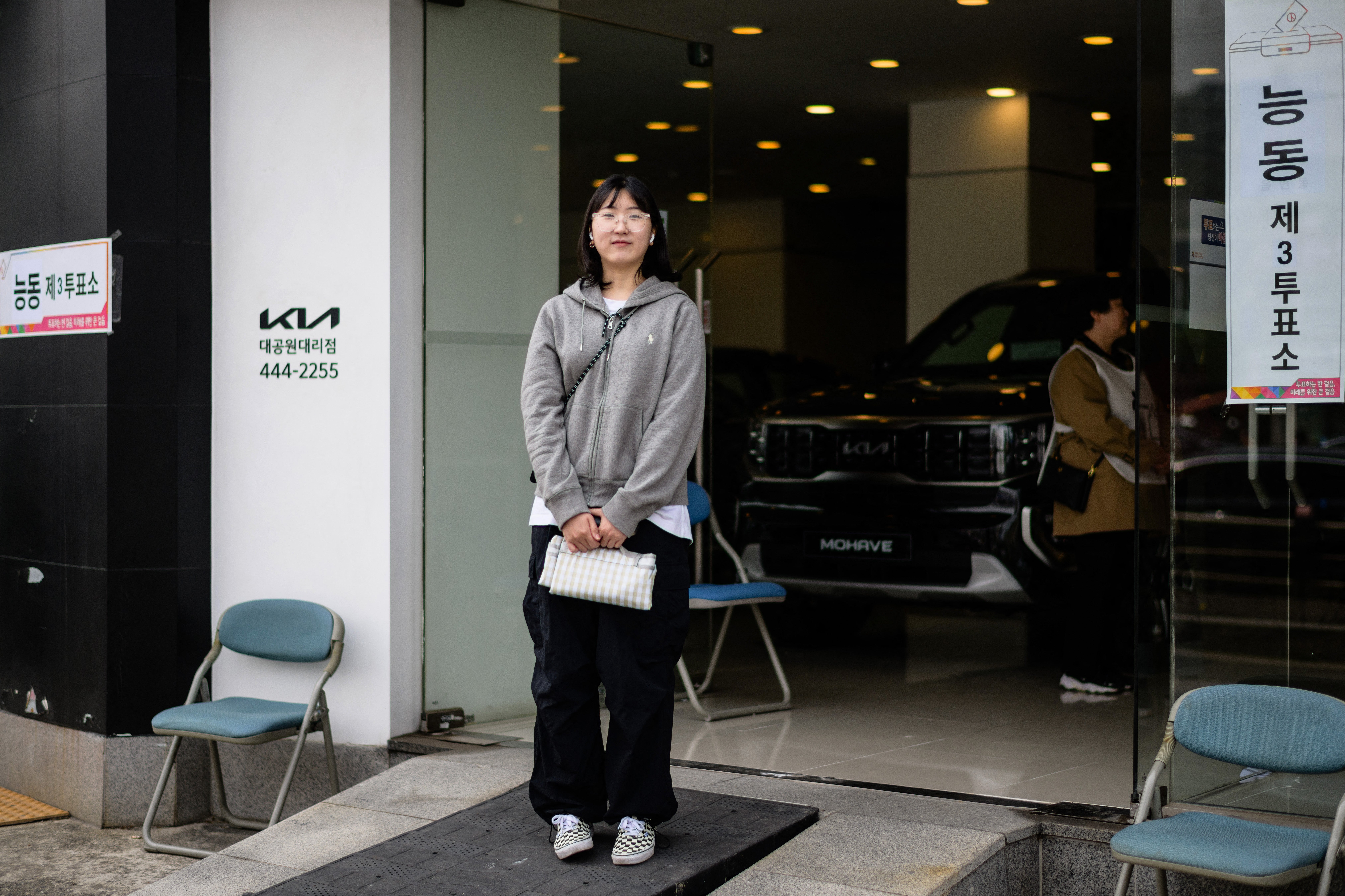 Choi Ji-sun, 25, exhibition designer, poses outside a polling station in Seoul on 10 April 2024, after voting during the parliamentary election